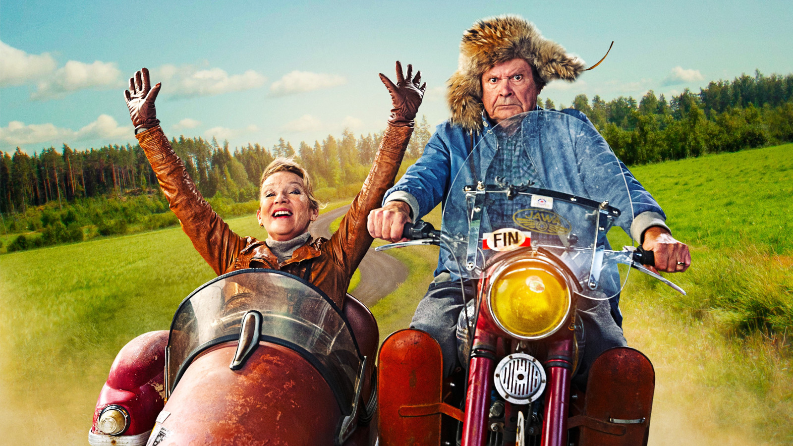 Kuvassa on Heikki Kinnunen ajamassa vanhaa moottoripyörää. Hänellä on sininen takki päällään ja karvahattu päässään. Vasemmalla on ruskeassa sivuvaunussa ja siinä istuu Jaana Saarinen kädet ylhäällä ruskeassa nahkatakissa. Taustalla on vihreää maalaismaisemaa.