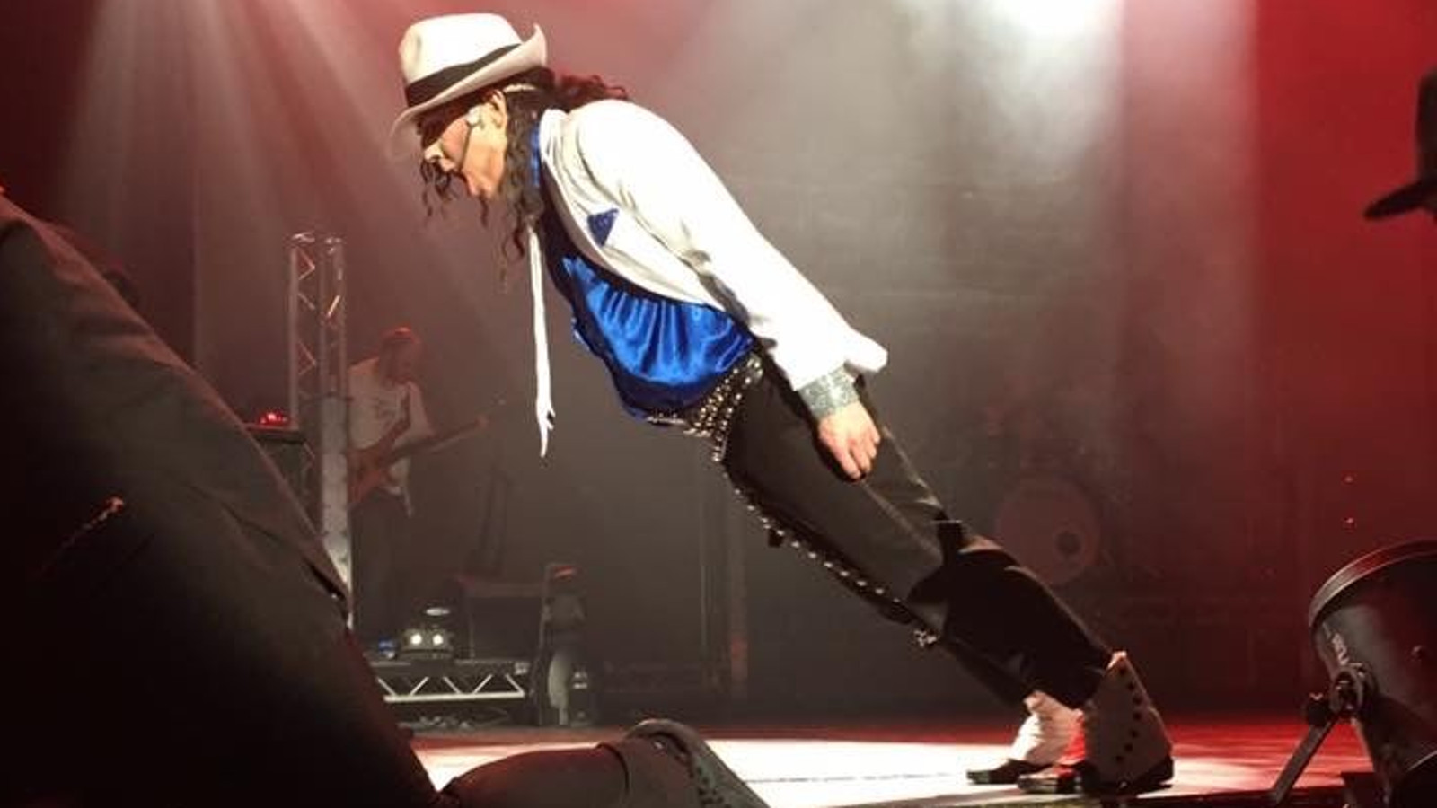 Kuvassa on Michael Jacksonia imitoiva miesesiintyjä sivuttain puoliksi taipuneena alaspäin.  Hänellä on vaalea hattu ja takki sekä kirkkaan sininen kiiltävä paita. Tausta on tumma.