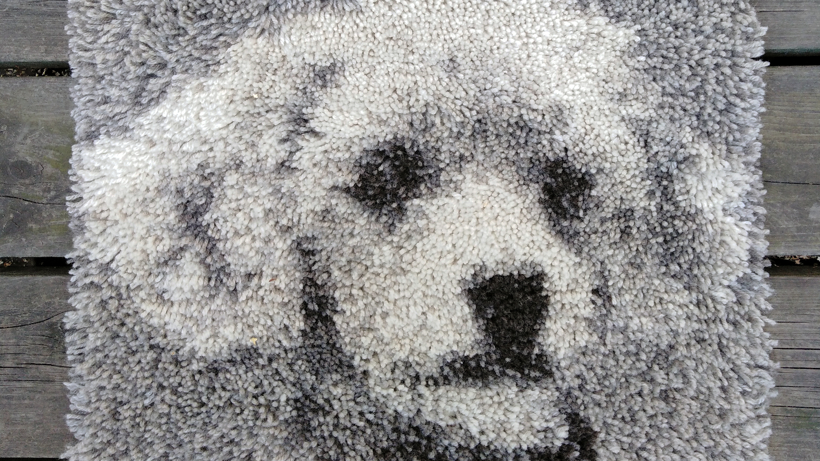 Kuvassa on Jenni Vanhasen ryijy Kiki, jossa on koiran kuva ja värit ovat mustaa, harmaata ja vaaleaa. 