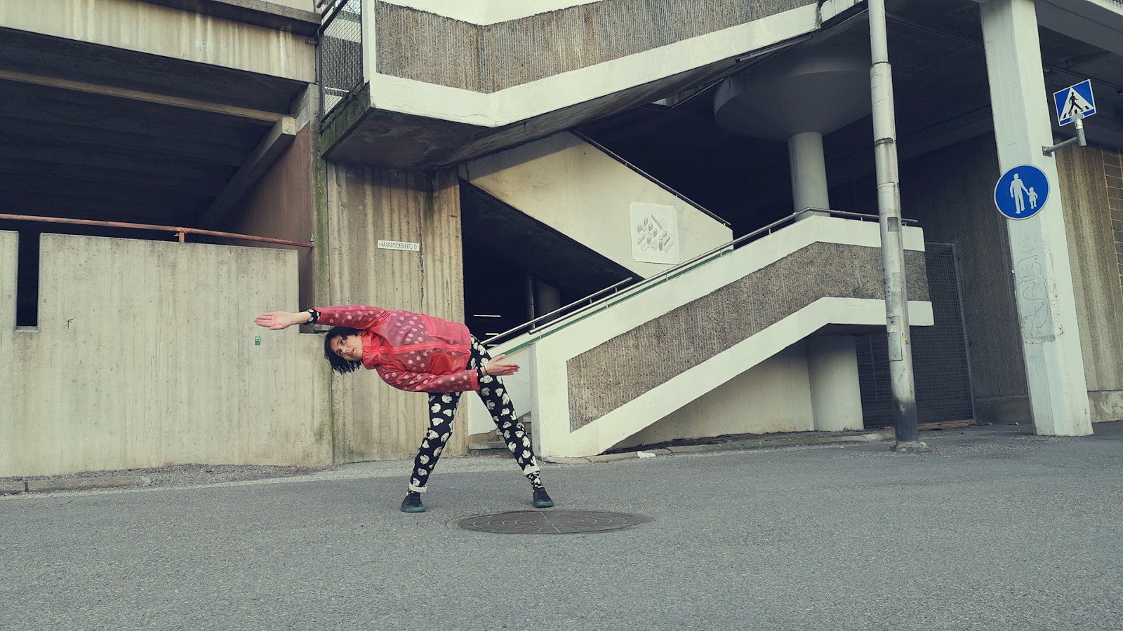 Kuvassa on tanssija Ella Effendy ja hän on taivutuksessa siksak-muotoisen betoniportaikon edessä. 
