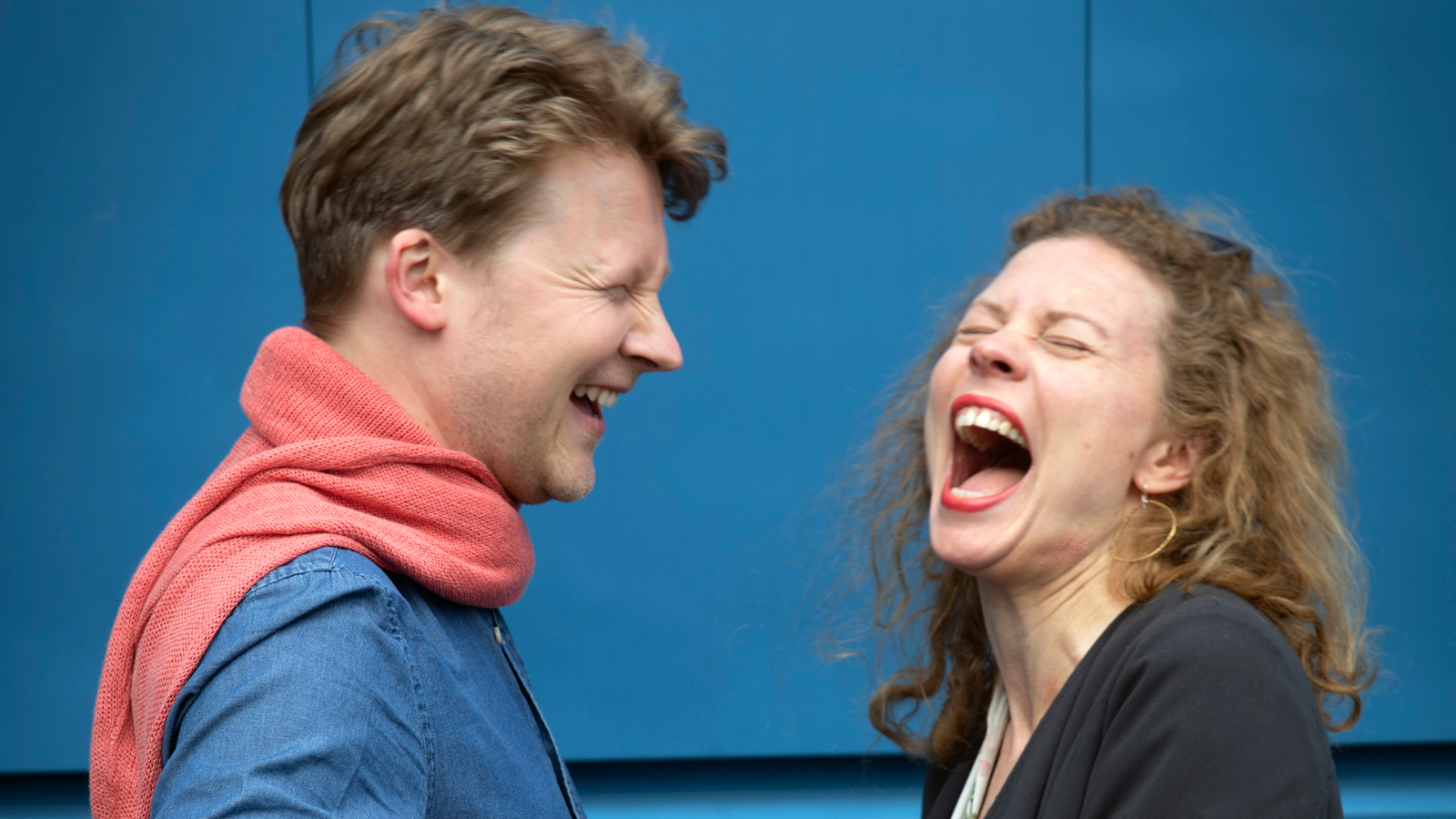 Kuvassa ovat Antti Tikkanen ja Minna Pensola iloisesti nauraen.  Kuva on puolivartalokuva.