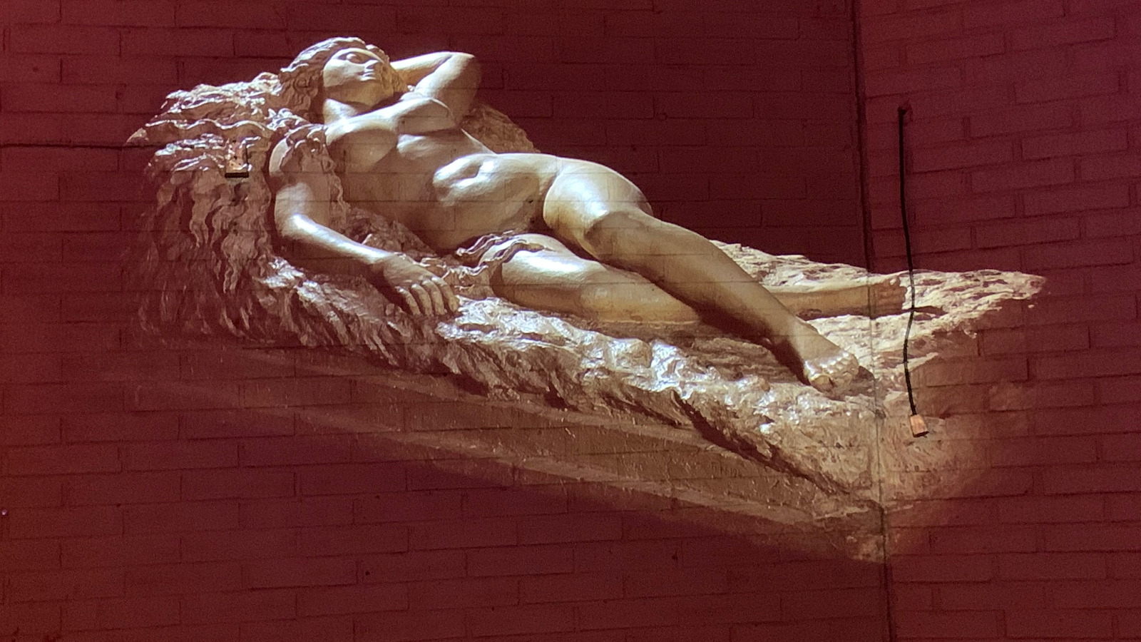 Kuvassa on digitoitu Kalevalan Kyllikki makaavana patsaana jalustan päällä.