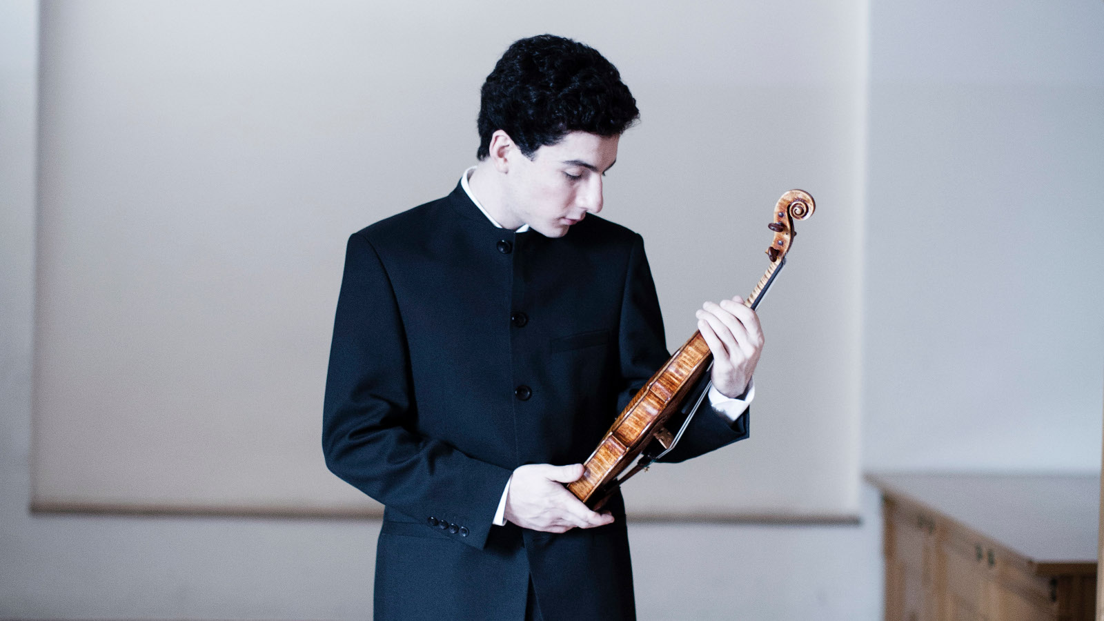 Kuvassa on viulisti Sergei Hatsarjan, joka katsoo viuluaan.  Kuva on musta-valkoinen.