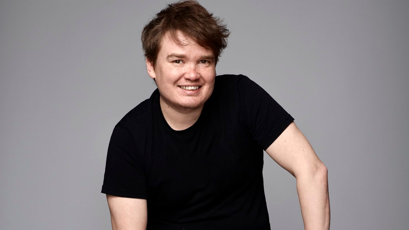 Kuvassa on Antti Heikkisen puolivartalokuva istumassa mustassa t-paidassa.