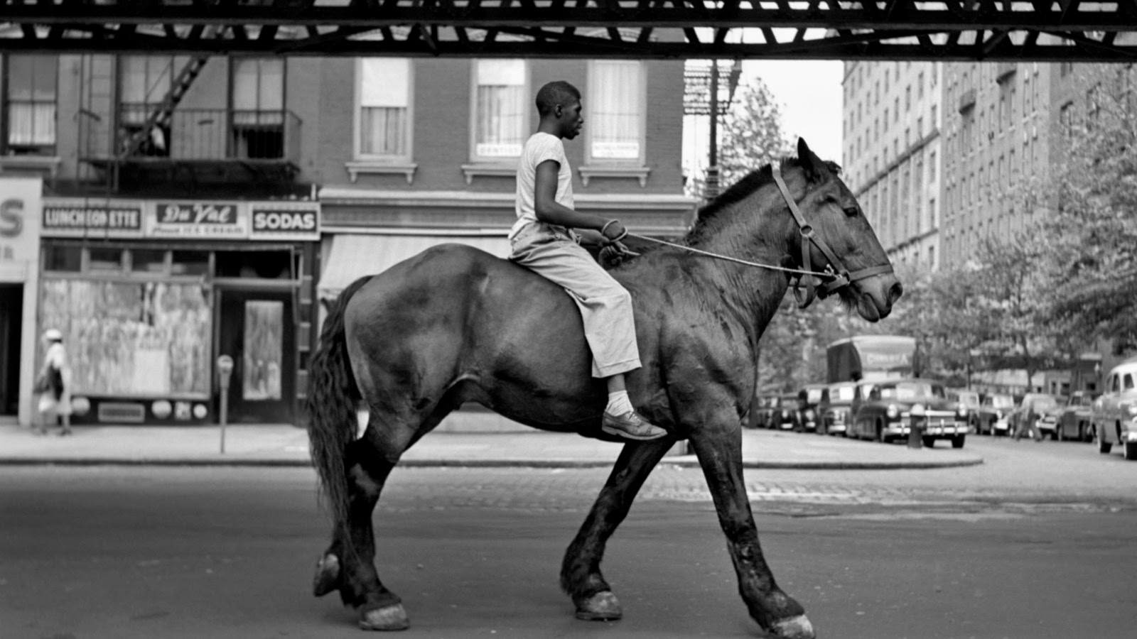 Kuvassa on ratsastaja hevosineen rautaisen sillan alla New Yorkissa.