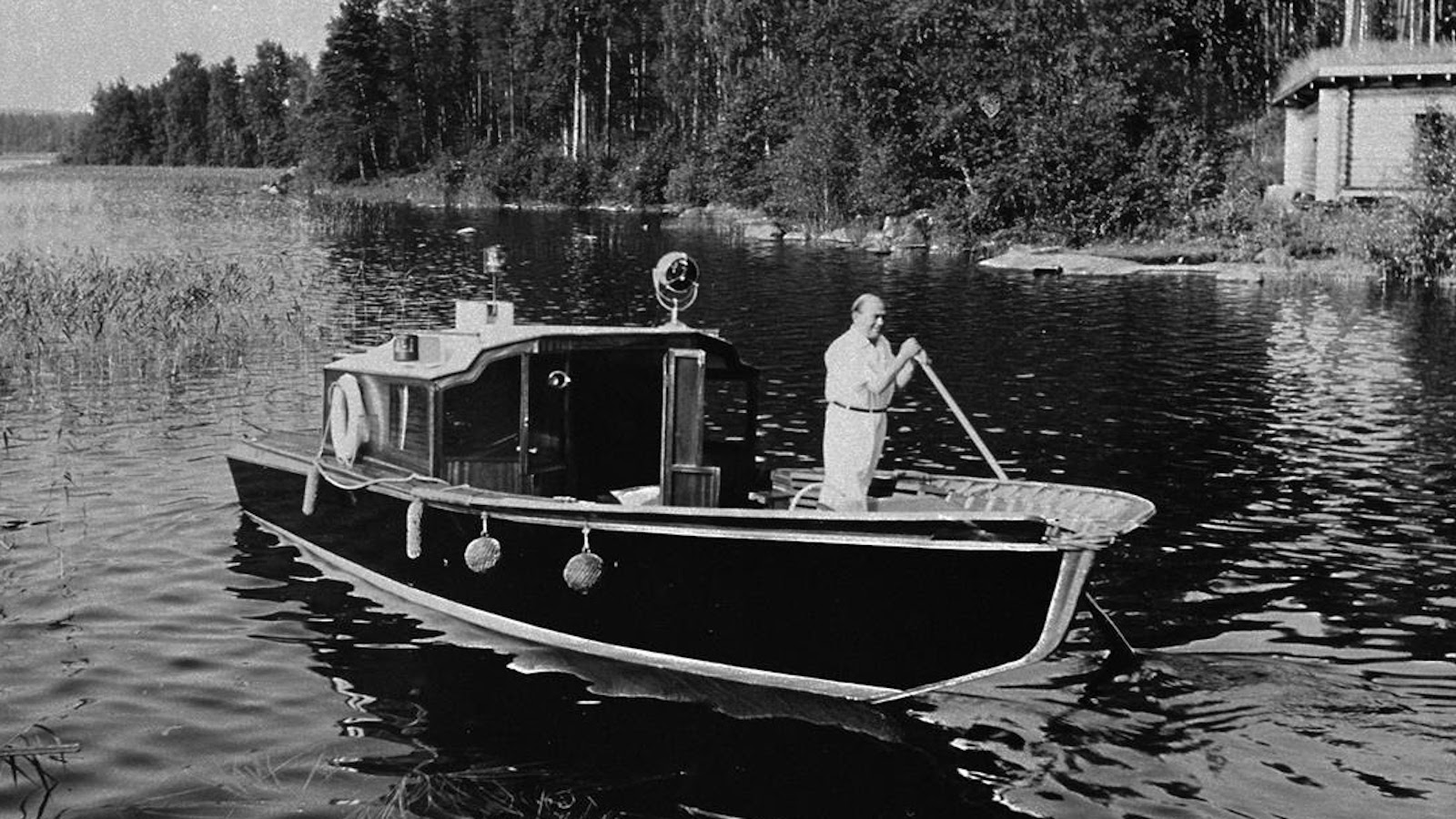 Alvar Aalto ohjaa suunnittelemaansa Nemo propheta in patria -venettä  Muuratsalon rannassa 1950-luvulla.