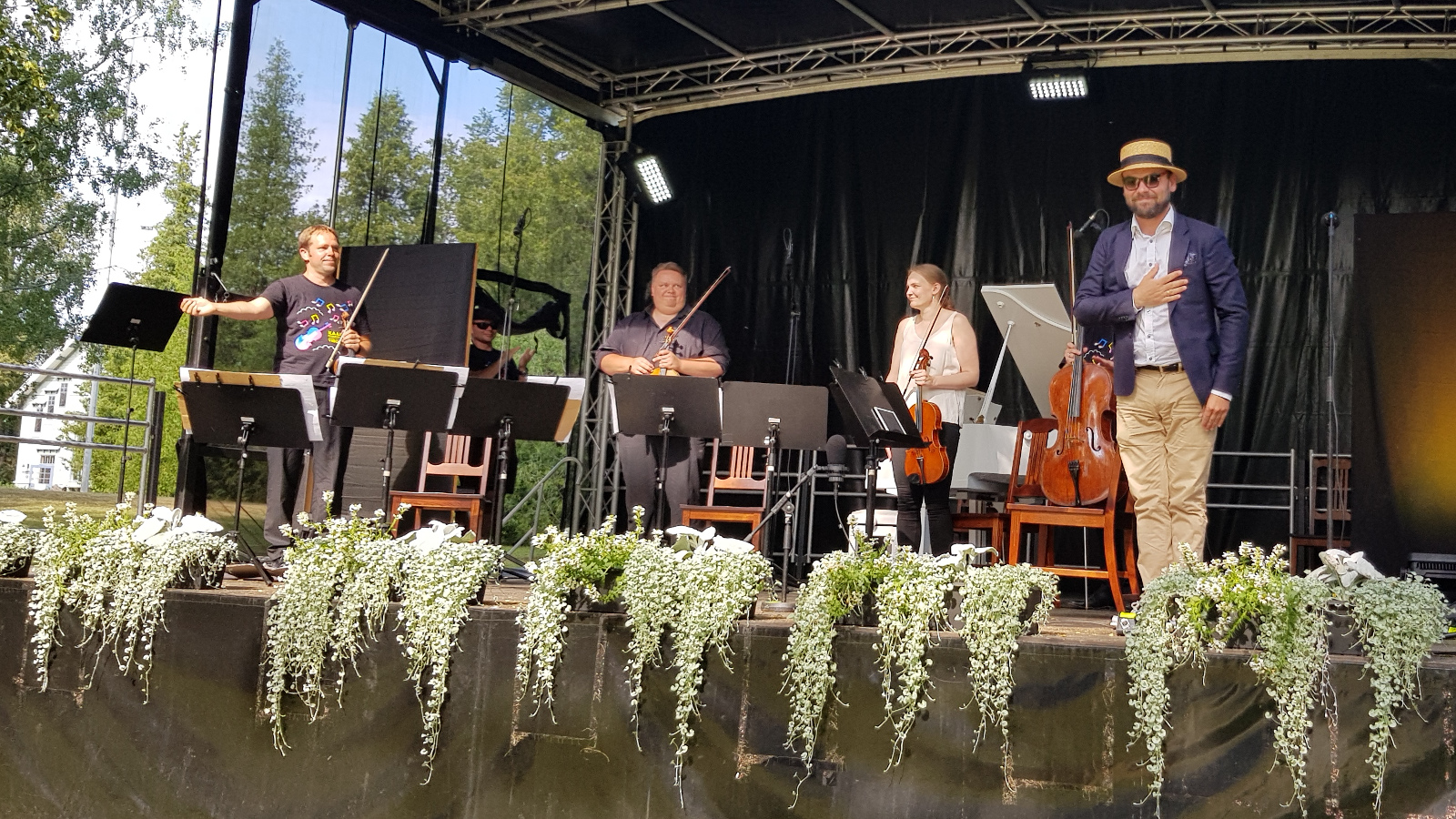 Kuvassa ovat kantaesityksen soittajat esiintymislavalla Jukka Merjanen vasemmalla, taaempana Ville Koponen ja oikealla Mari Viluksela ja hänen edessään Ville Matvejeff käsi sydämellään vaalea lierihattu päässään.