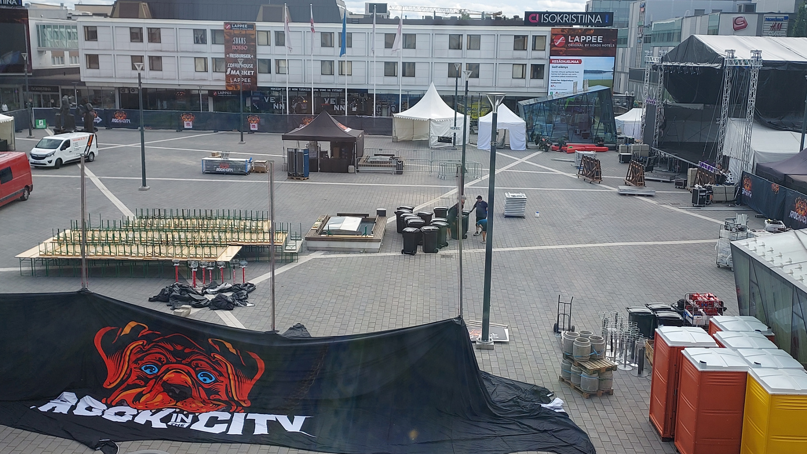 Kuvassa on Lappeerannan kansalaistori, jota valmistellaan Rock In The City -festivaalia varten. Etualalla näkyy telttoja ja oikealla näkyy esiintymislavaa.