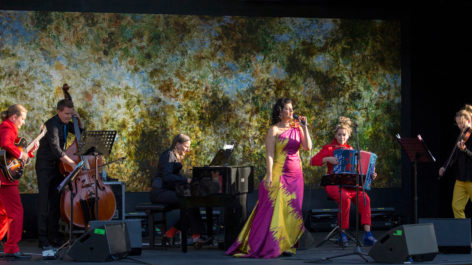 Kuvassa on Angelika Klas ja Kotaja Quintet esiintymässä hajaantuneena tasaisesti värikkäällä lavalla.