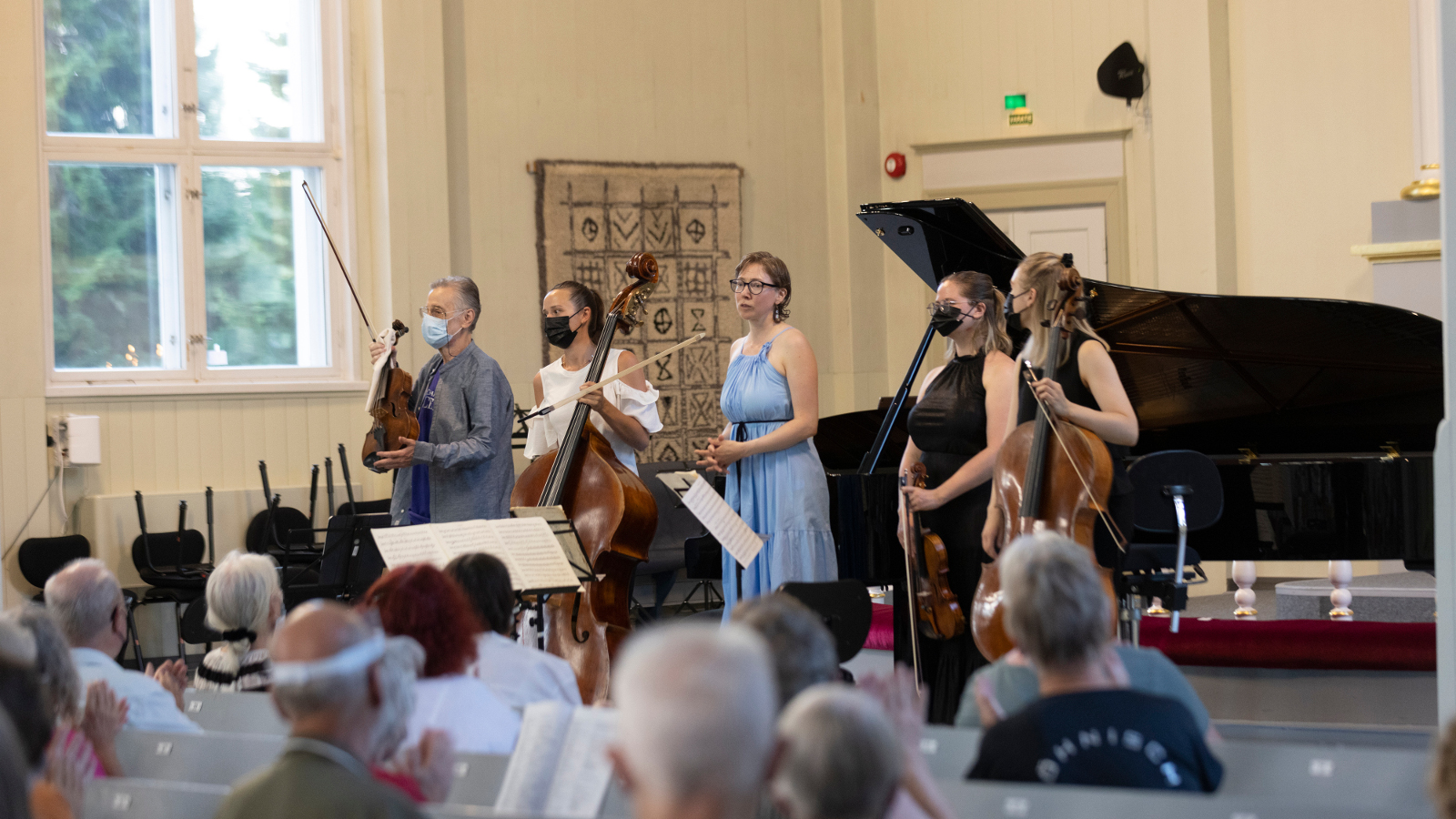 Kuvassa on Vladimir Mendelssohn vasemmalla ja neljä muuta soittajaa kiittämässä konsertista Kuhmon kirkossa.