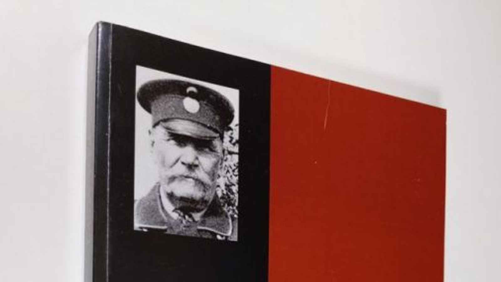 Kuvassa on osa kansikuvasta Erkki Toivosen kirjassa ja siinä on vasemmalla musta-valkoinen kuva vanhasta miehestä.  Muu osa on punaista.