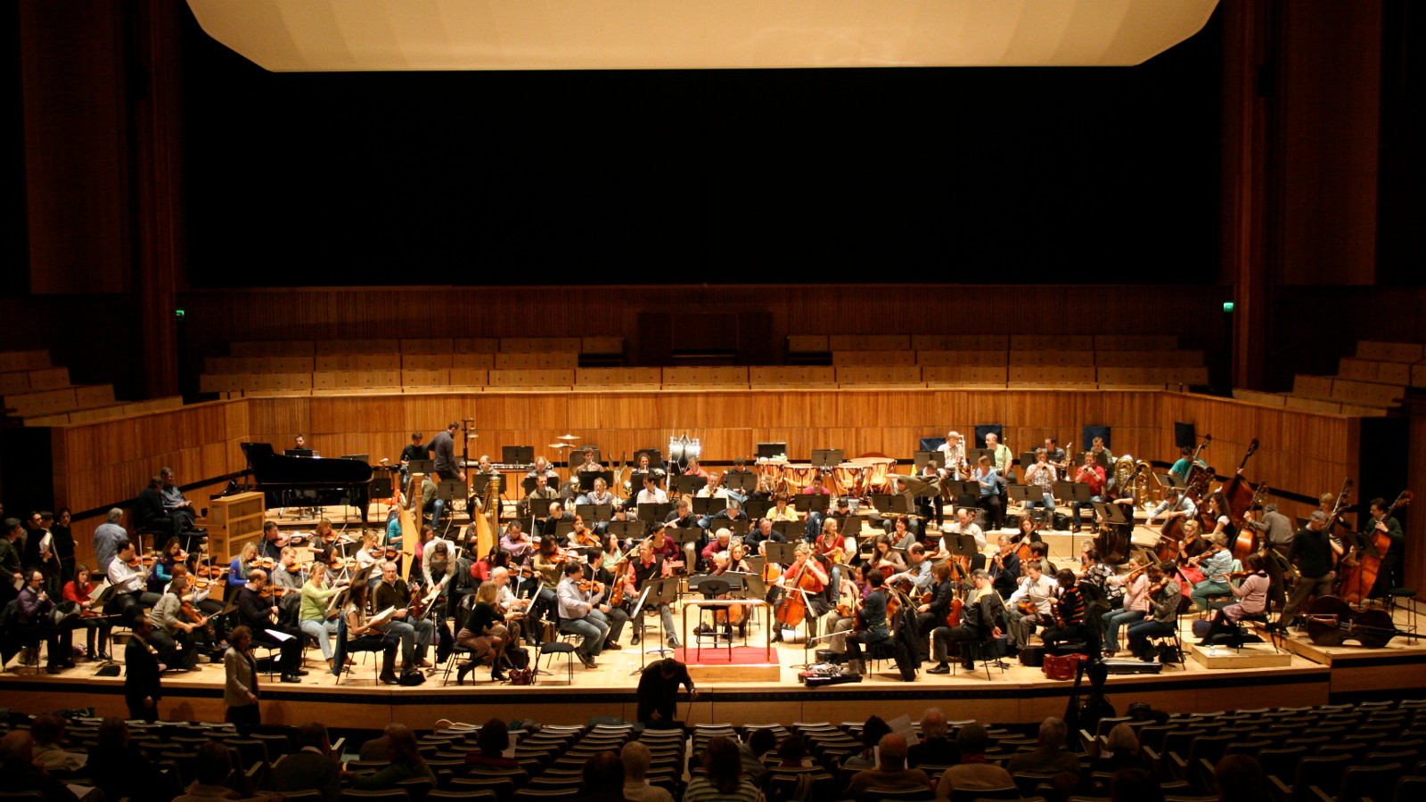 Kuvassa on Lontoon filharmoninen orkesteri harjoittelemassa orkesterilavalla.