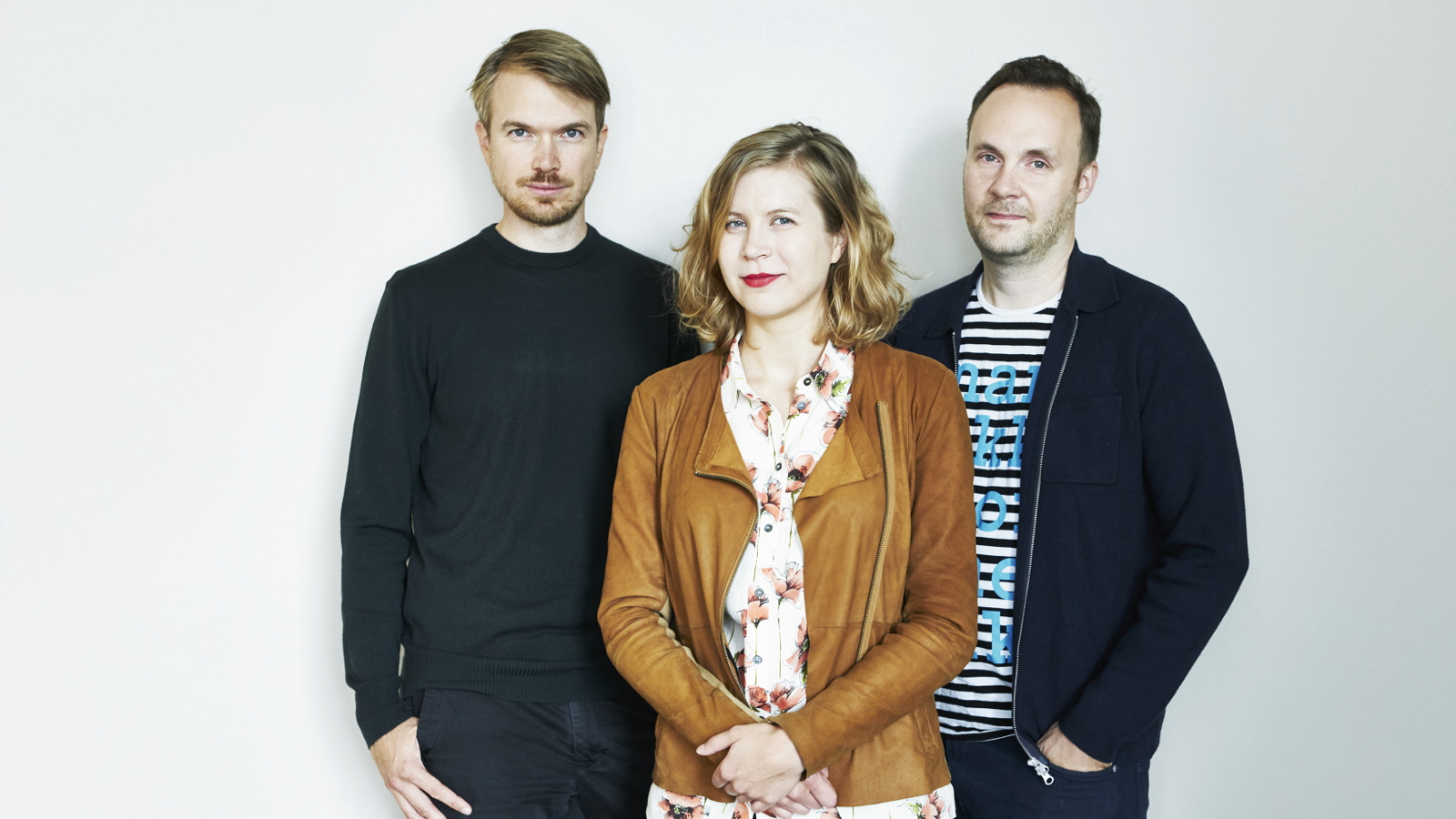 Kuvassa ovat Johannes Koponen, Minea Koskinen ja Jussi Pullinen rennoissa vaatteissa puolivartalokuvassa.
