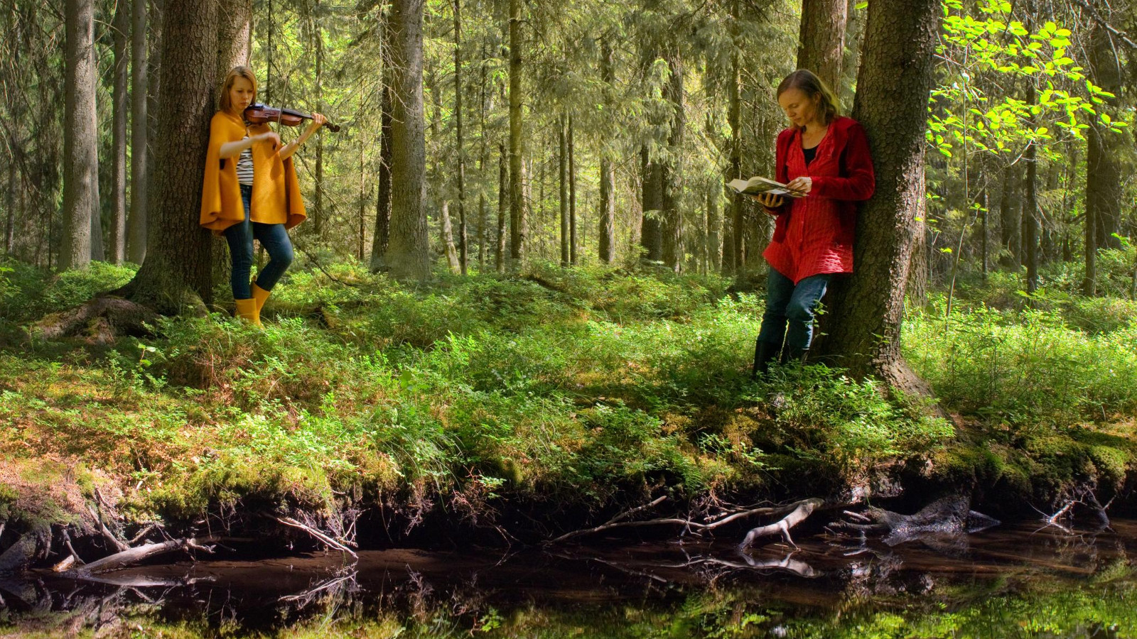 Kuvassa ovat metsässä seisomassa Anni Kytömäki ja Viola Räisänen ja edessä on lampi. 