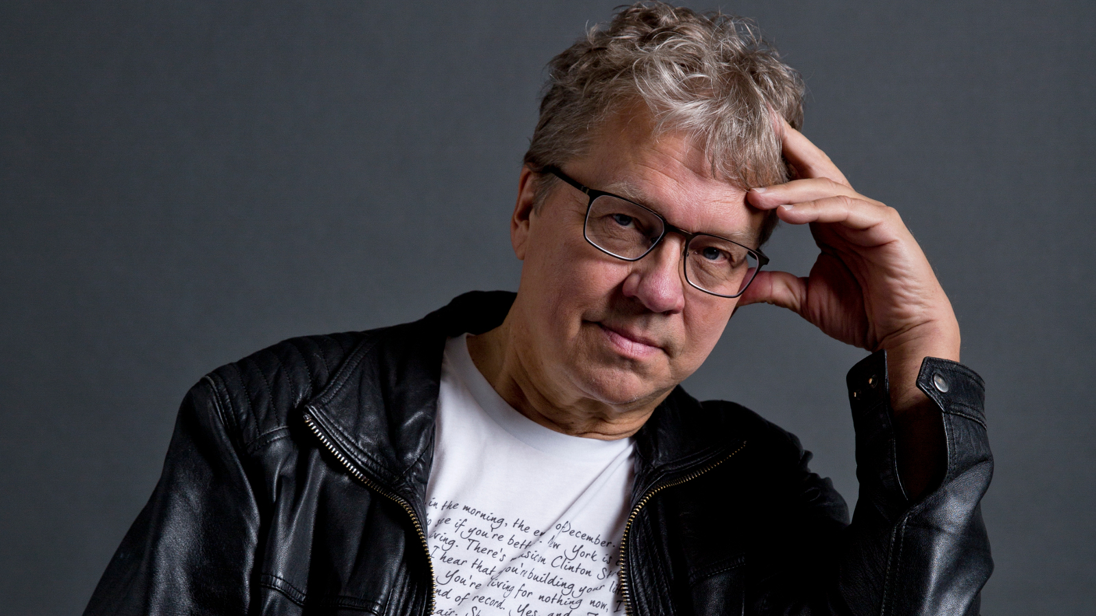 Kuvassa on Pekka Sauri, joka nojaa vasempaan käteensä istuessaan.