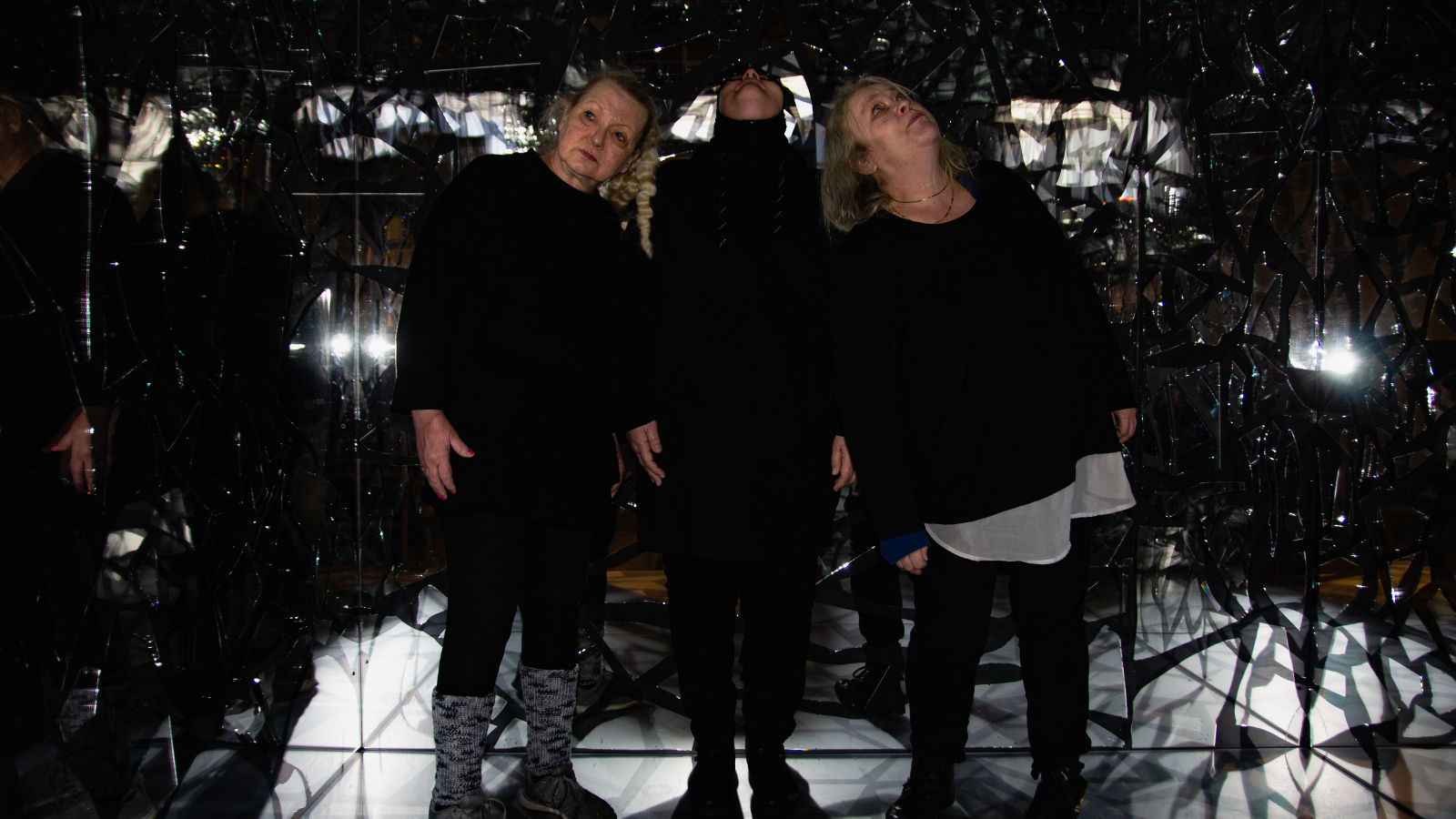 Kuvassa on tummassa tilassa Ritva Sorvali, Eveliina Lafghani ja Helena Ryti tiiviinä ryhmänä keskellä. Keskellä olevalla Lafghanilla on pää ylöspäin.