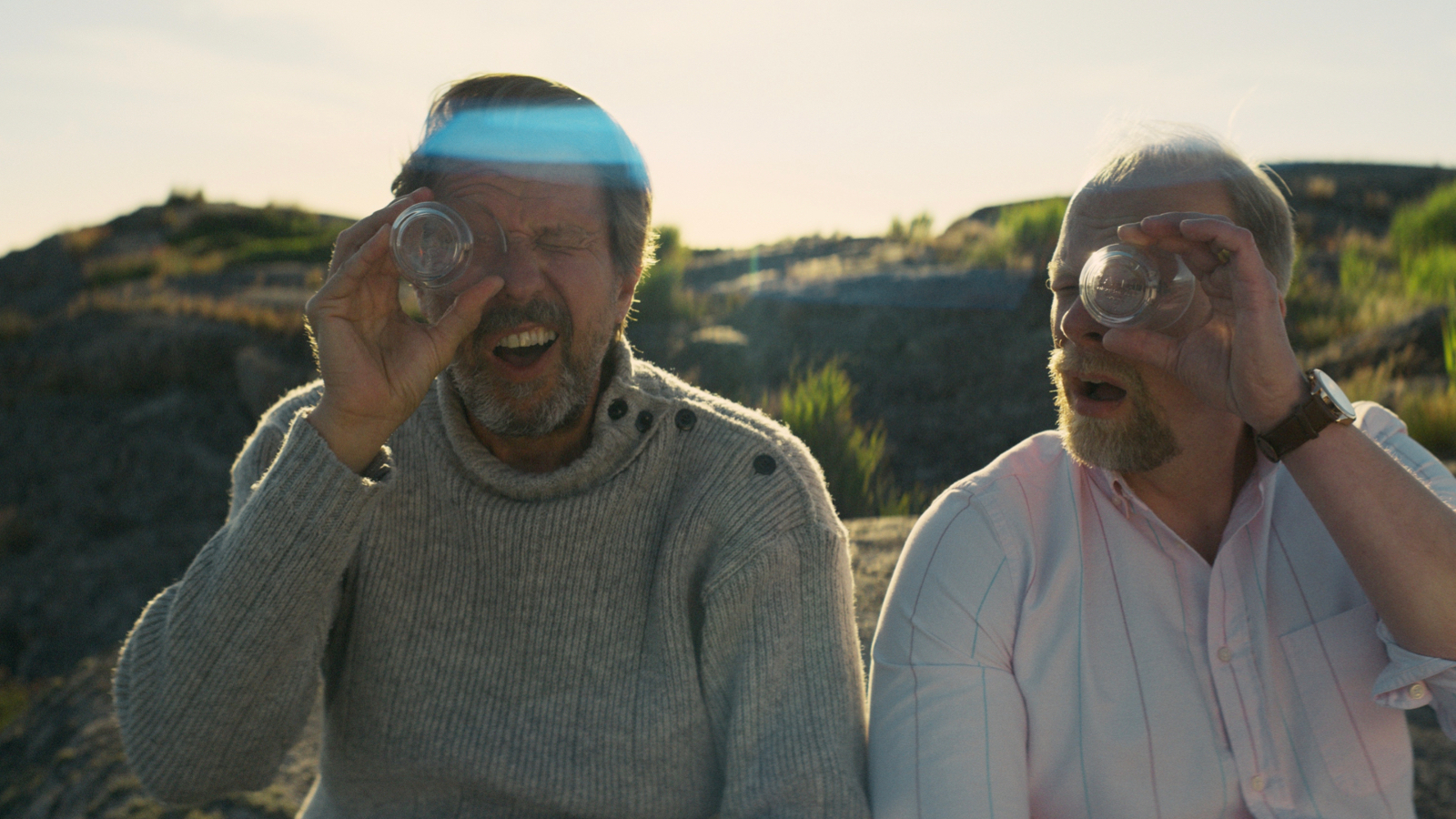 Kuvassa ovat Martti Suosalo ja Ville Myllyrinne, jotka katsovat toisella silmällä lasinpohjan läpi. 