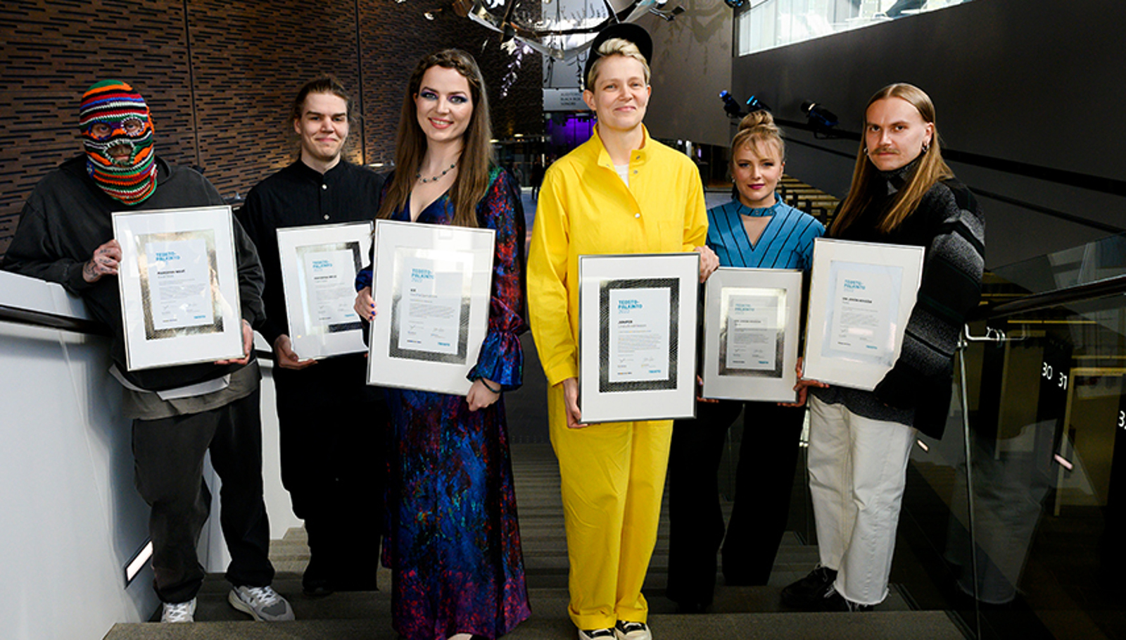 Kuvassa ovat Teosto-palkinnon saajat kuusi henkilöä palkintokunniakirjat kädessään.