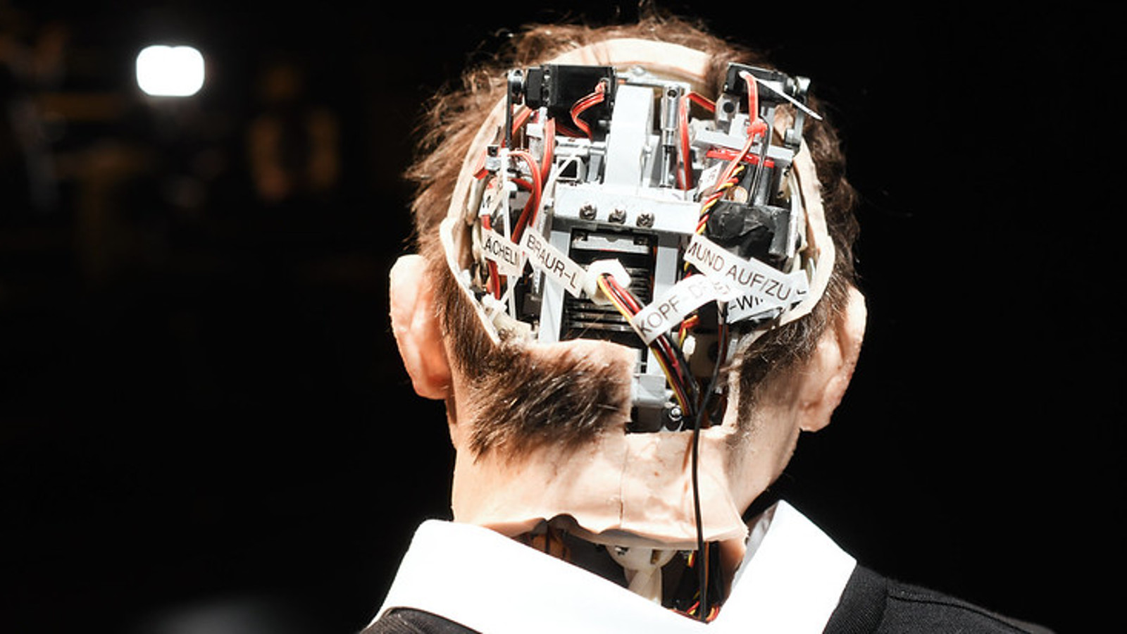 Kuvassa on miehen takaraivo, jossa on aivojen kohdalla tietokoneen koneistoa.