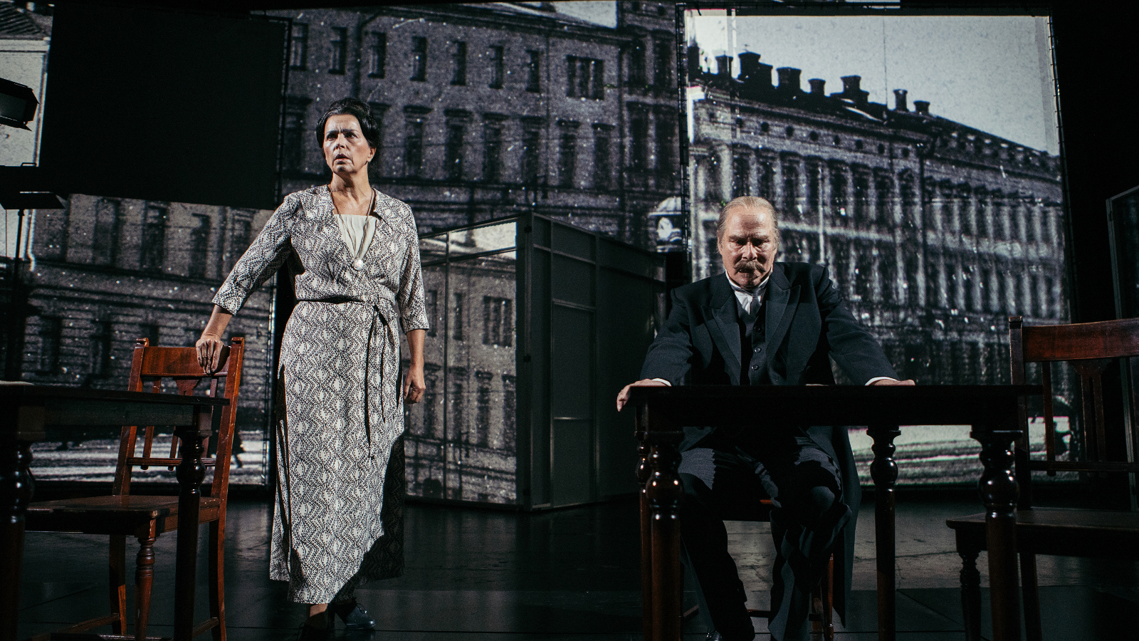 Kuvassa on taustalla presidentin linna ja etualalla vasemmalla on Kristiina Halttu Esterinä harmaa kuvioisessa puvussa seisomassa ja oikealla Vesa Vierikko istumassa.