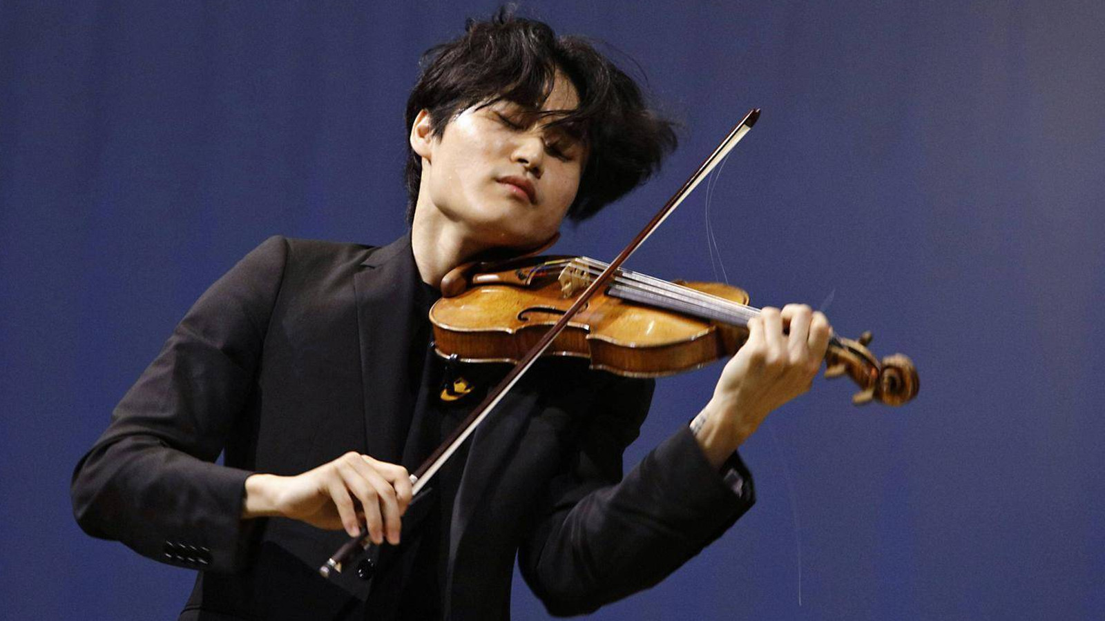 Kuvassa on Inmo Yang soittamassa viulua ja kuva on puolivartalokuva alaviistosta.