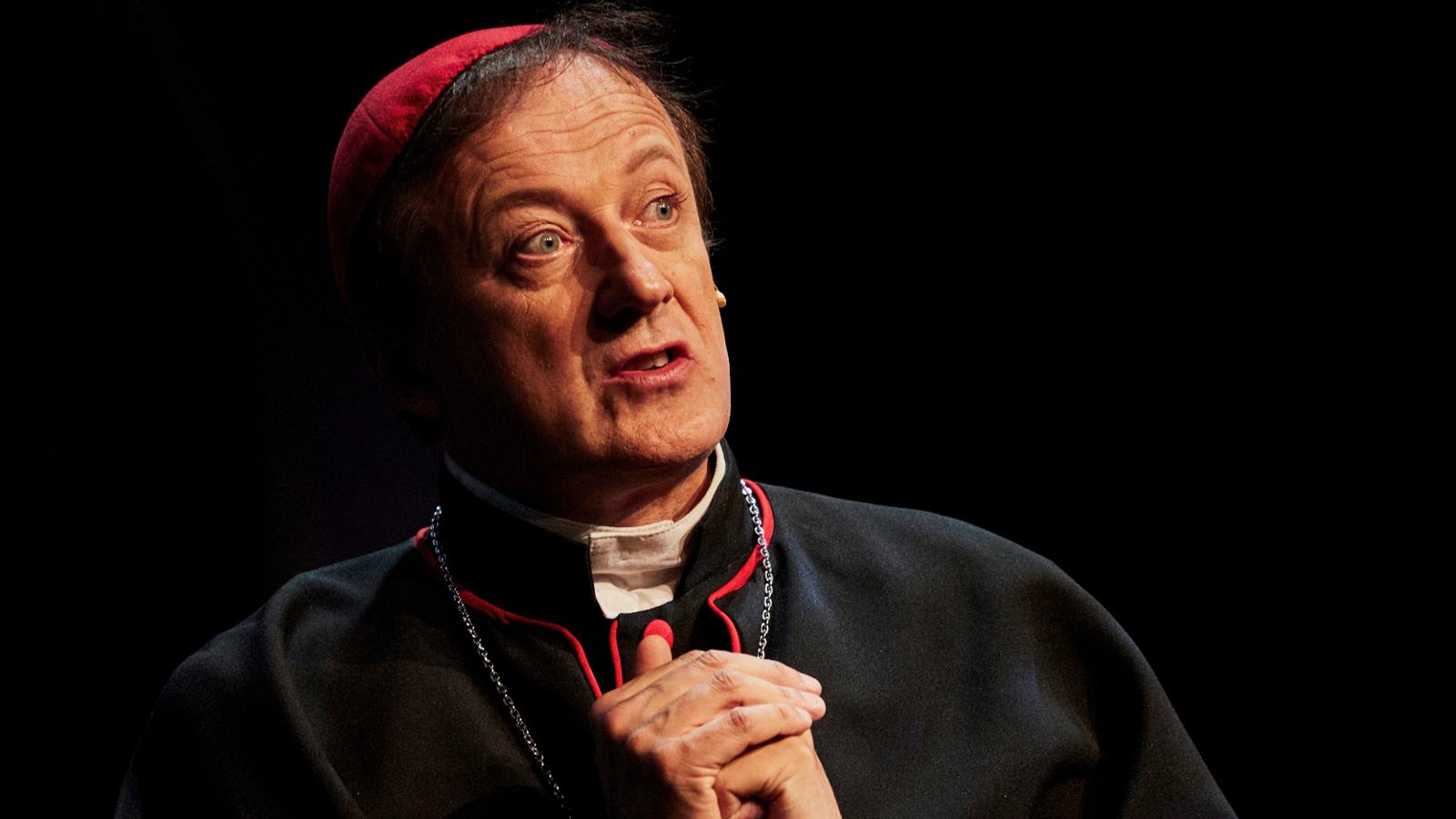 Kuvassa on Kari Koivukangas piispan punainen kipa päässään. Kuva on kasvokuva.