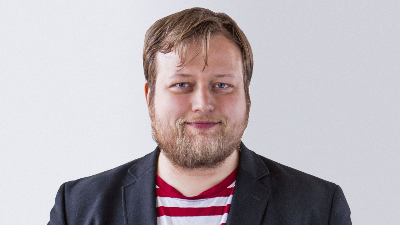Kuvassa on Lauri Maijala puolivartalokuvassa mustassa pikkutakissa puna-valkoraitaisessa t-paidassa.
