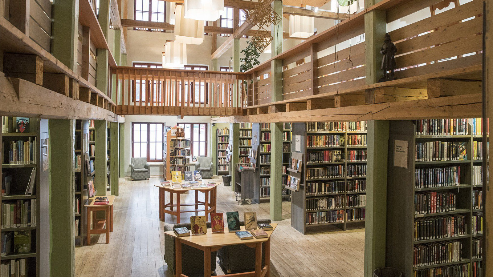 Kuvassa näkyy Tyrnävän kirjaston hyllyjä ja miljöötä, joka on vanhahtavan historiallisen näköinen ja ruskehtavaa väriltään.