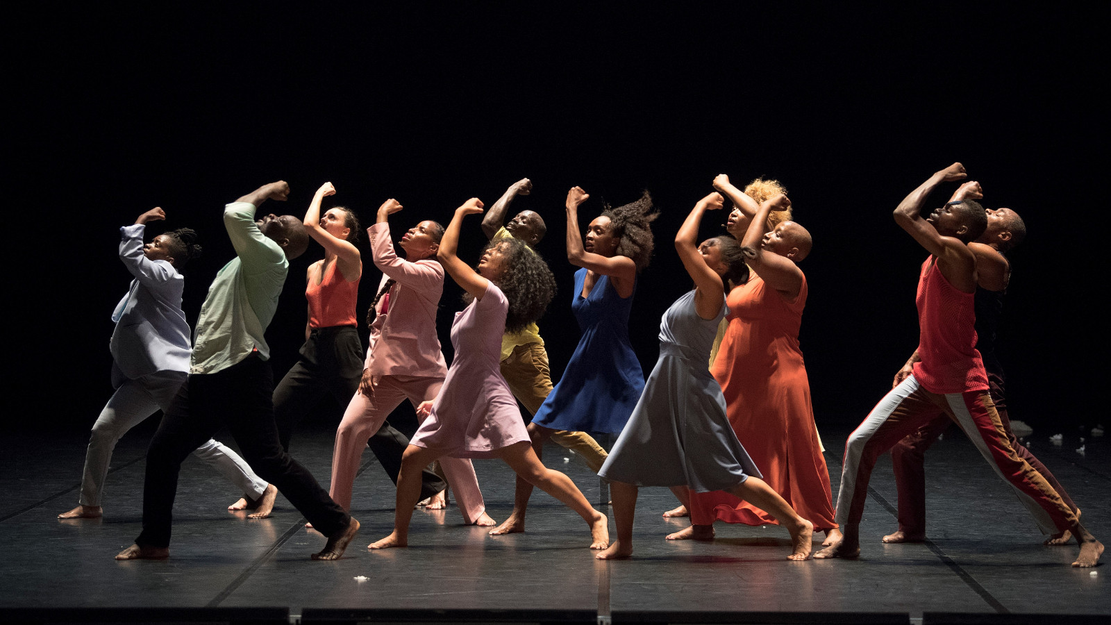 Kuvassa ovat Cie Salia Sanoun tanssijoita liikkeessä vasemmalle ja jokaisella on vasen käsi koukussa ylöspäin.