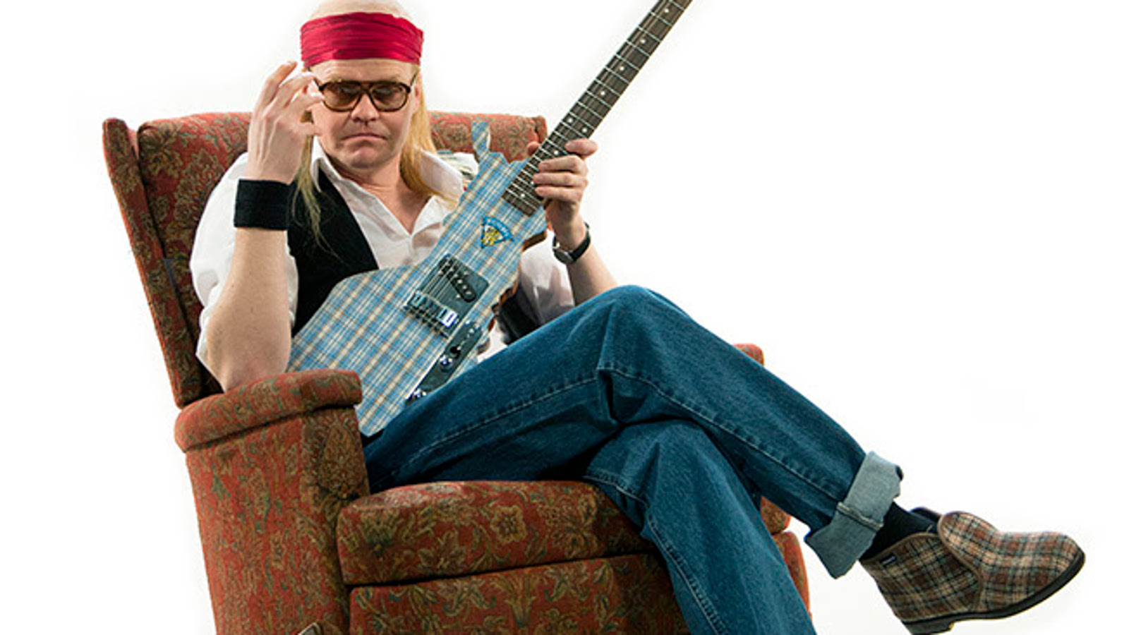 Kuvassa on Otto Kanerva Juicena istumassa ruskeassa nojatuolissa ja kitara kädessään.  Hänellä on punainen nauha päässään.