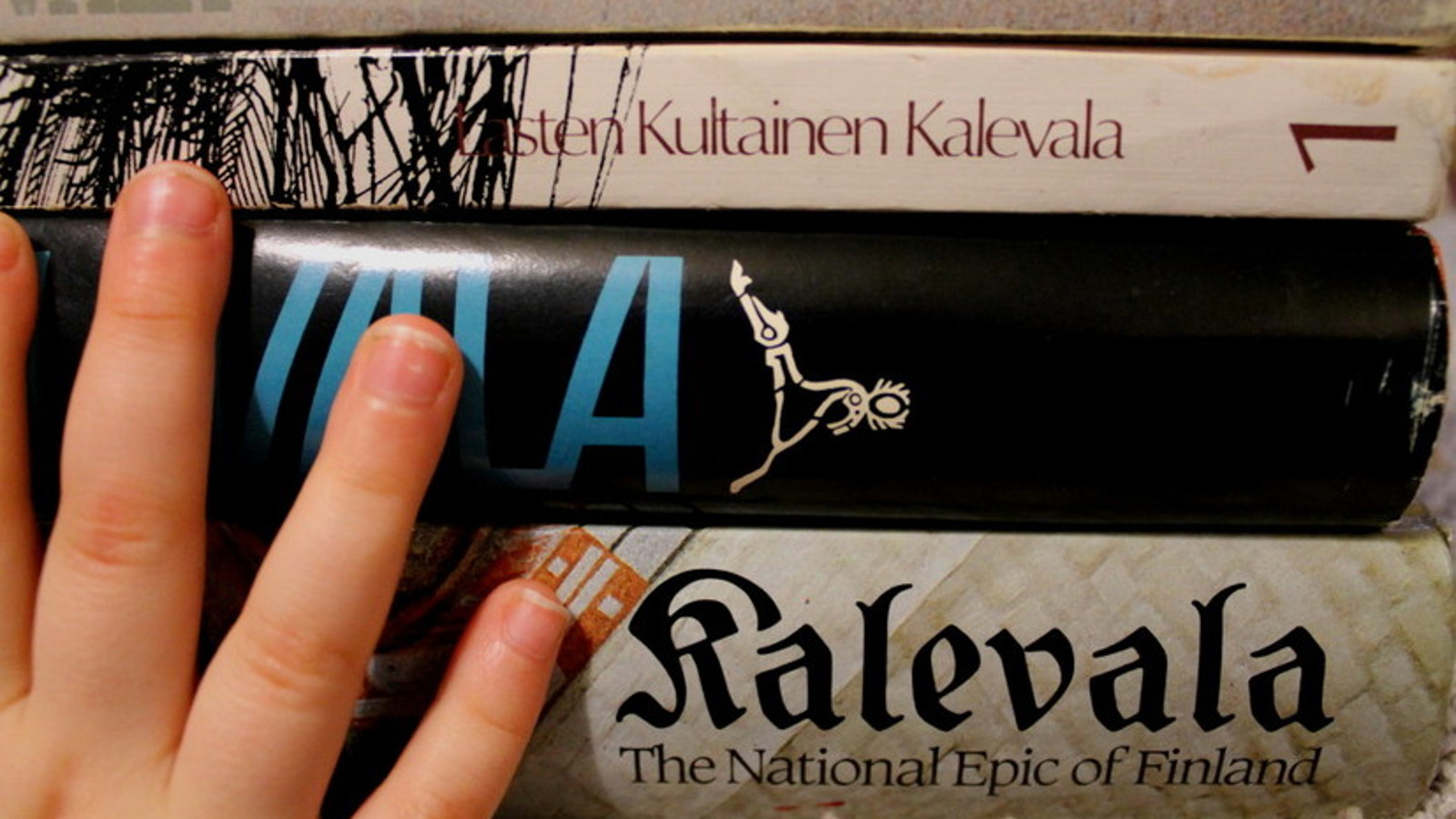 Keskellä lukee fraktuuralla Kalevala ja alempana on lasten Kalevala. 