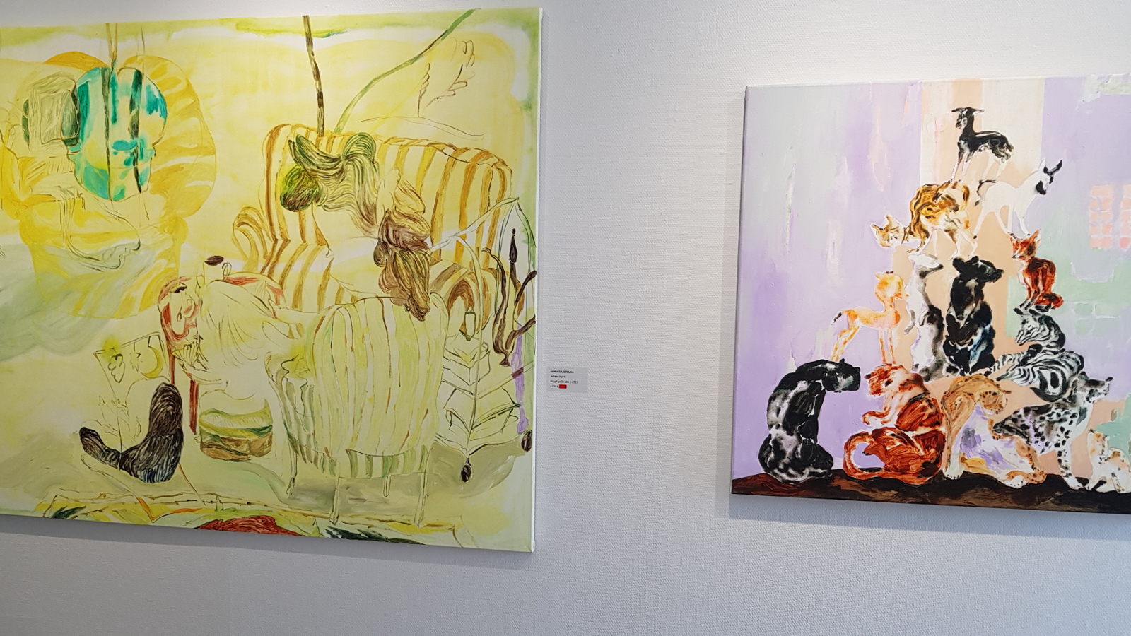 Kuvassa on Juliana Hurrin kaksi teosta, josita vasemmalla on suurempi keltainen ja siinä on erilaisia hahmoja.  Oikealla on punertava sävyinen teos ja siinä on pyramidimaisesti erilaisia esineitä päällekkäin.