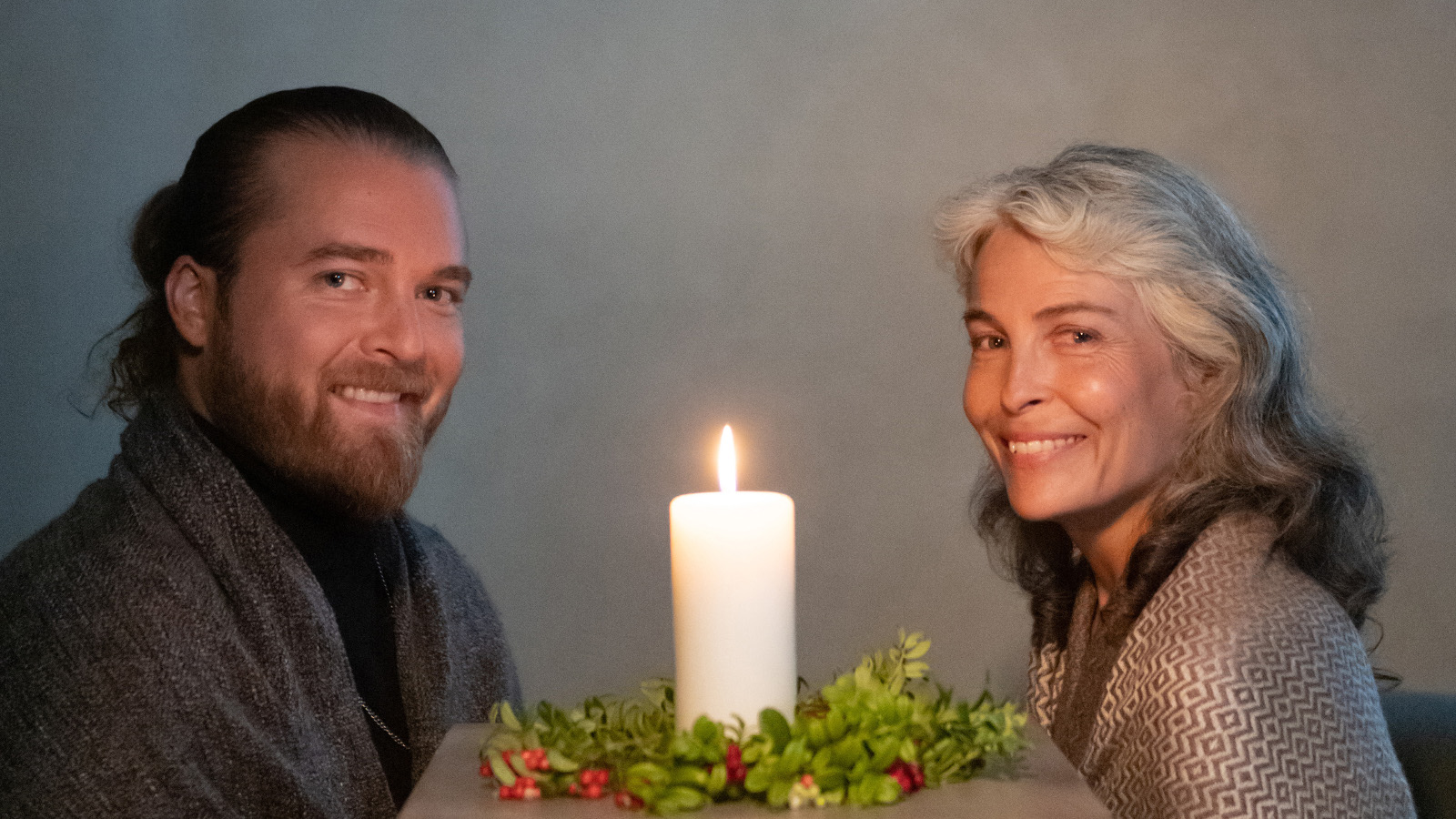 Kuvassa ovat istumassa Teemu Roivainen vasemmalla ja Irina Björklund oikealla. Heistä on puolivartalokuva. Roivaisella on tumman harmaa takki ja Björklundilla vaalea jakku päällään. Heidän keskellään on kynttilänliekki.  