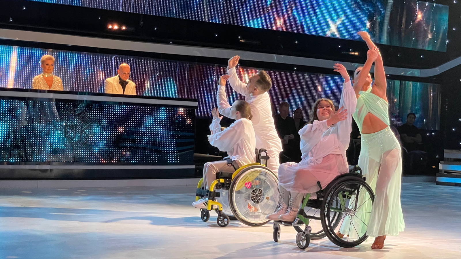 Kuvassa ovat Matti vasemmalla ja hänen edessään pyörätuolissa Viivi Aalto. Oikealla on Katri vaalean vihreässä puvussa ja hänen edessään on Helmi Saxberg pyörätuolissa valkoisessa paidassa.