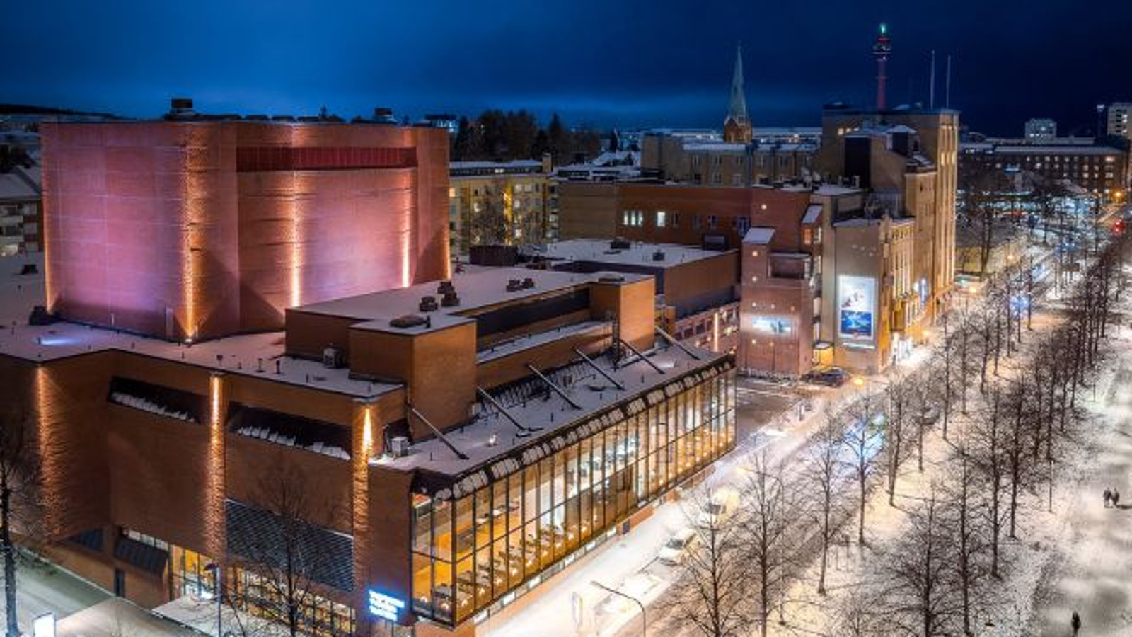 Kuvassa on Tampereen Työväen Teatterin punatiilinen rakennus ylhäältä päin kuvattauna iltavalaistuksessa.