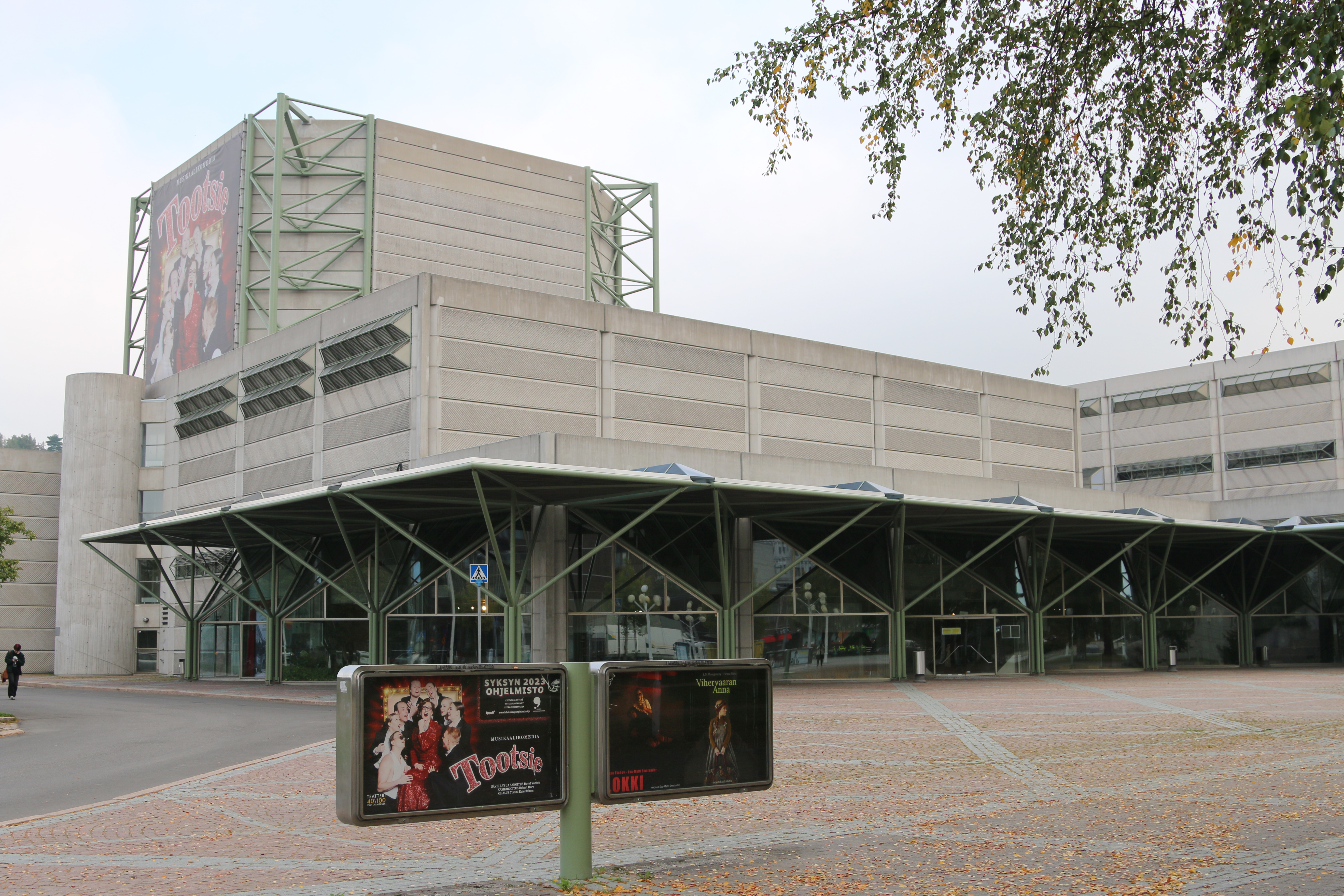Kuvassa on Lahden kaupunginteatteritalo, joka on harmaata betonia ja siinä on metallirakenteita.