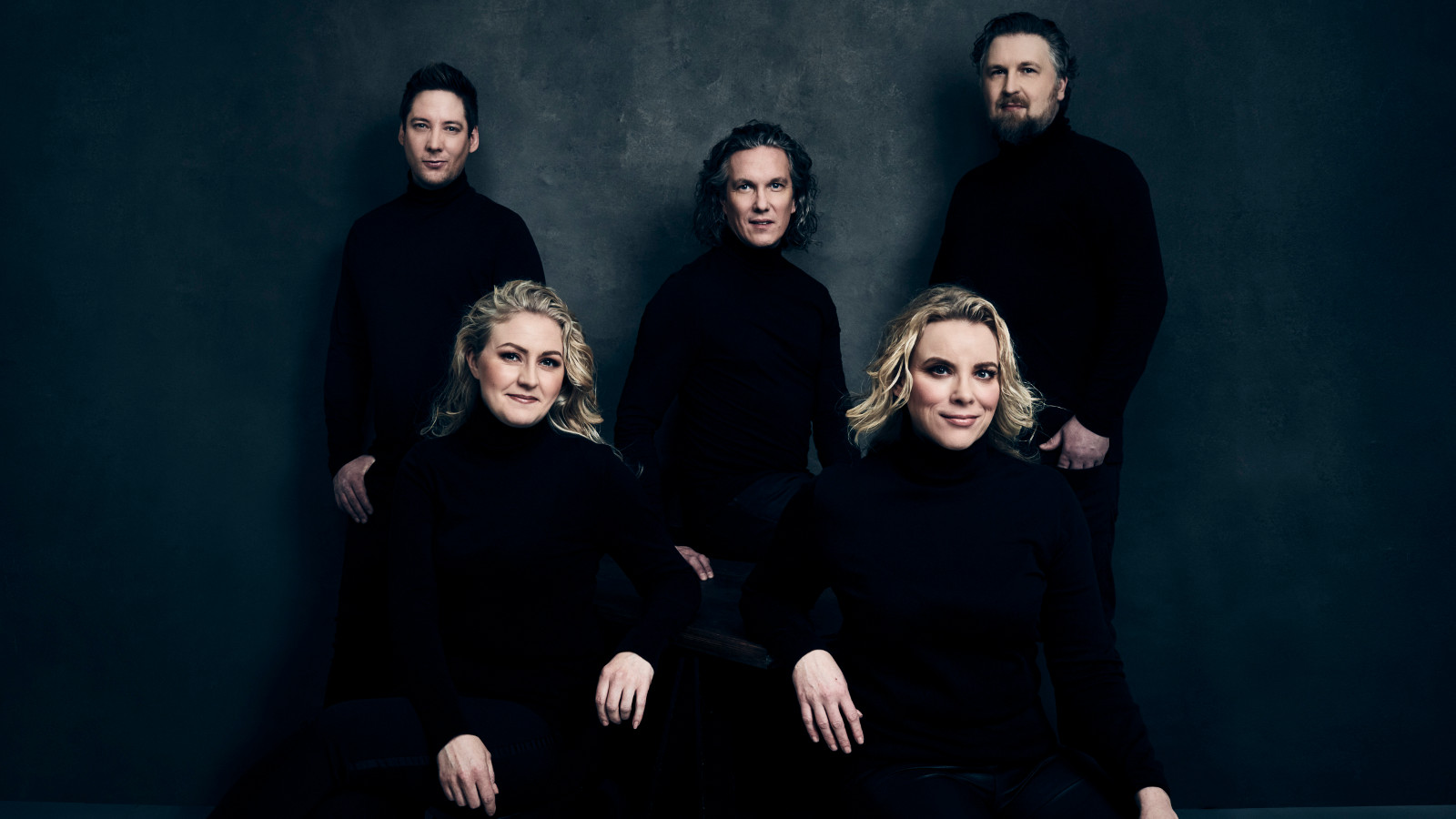 Kuvassa ovat Club for Fiven viisi laulajaa siten, että heistä kaksi miestä seisoo takana ja keskellä istuu yksi nainen.  Edessä istuu kaksi naista.  Kaikilla on mustat vaatteet ja tausta on tumma.