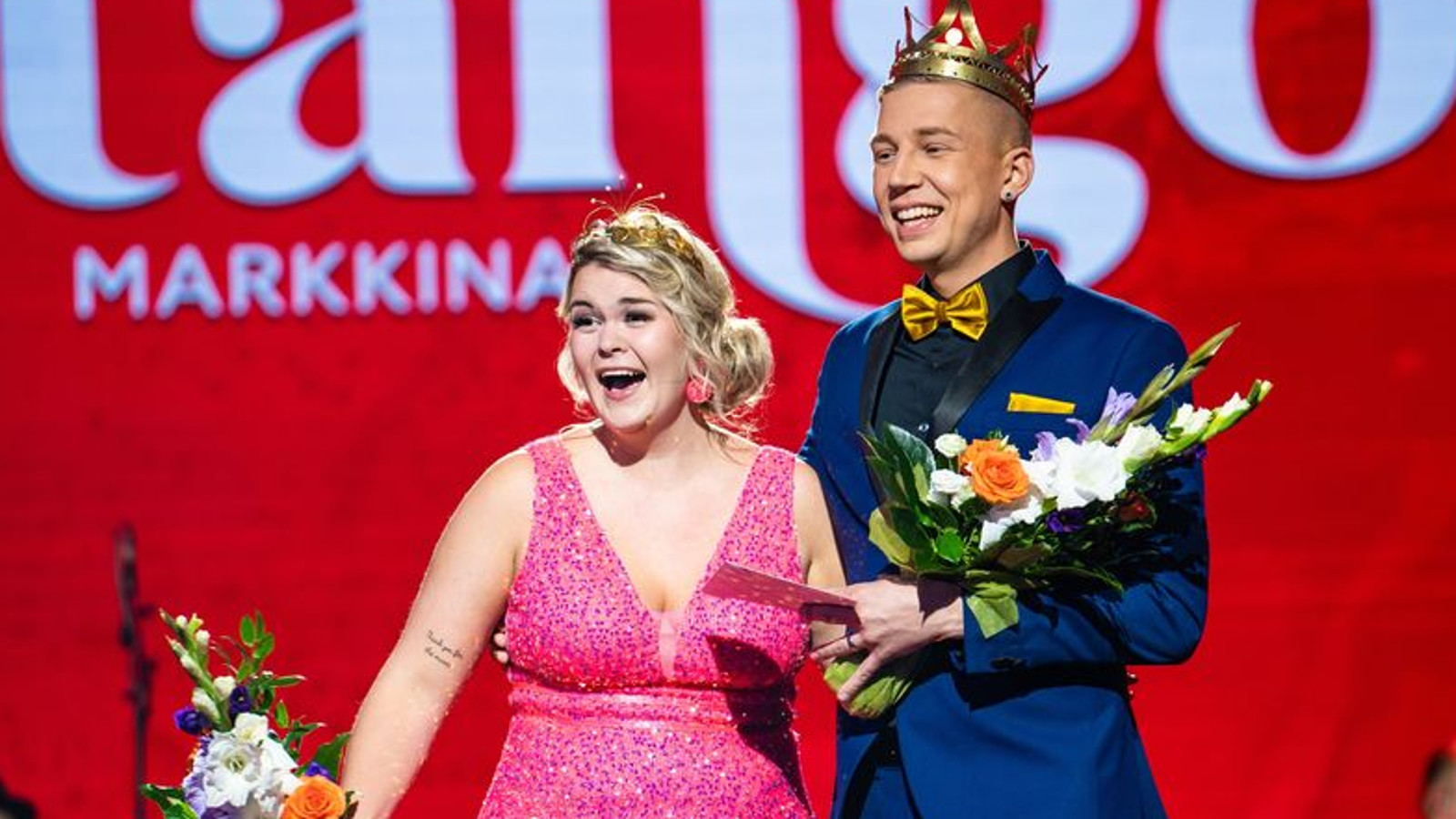 Kuvassa on ovat tangokuninkaalliset Charlotta Paasi pinkissä puvussa ja oikeassa kädessään kukat. Oikella on Pasi Flodström ja hänellä on sininen puku sekä keltainen rusetti ja taskuliina. Taustalla on punaisella pohjalla isolla tango ja pienemmin kirjaimin markkinat.
