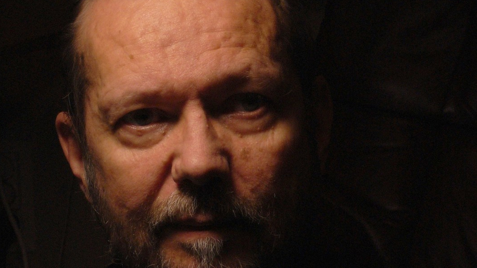 Kuvassa on Jukka Tiensuu kasvokuvassa ja osa kasvoista on tummaa.