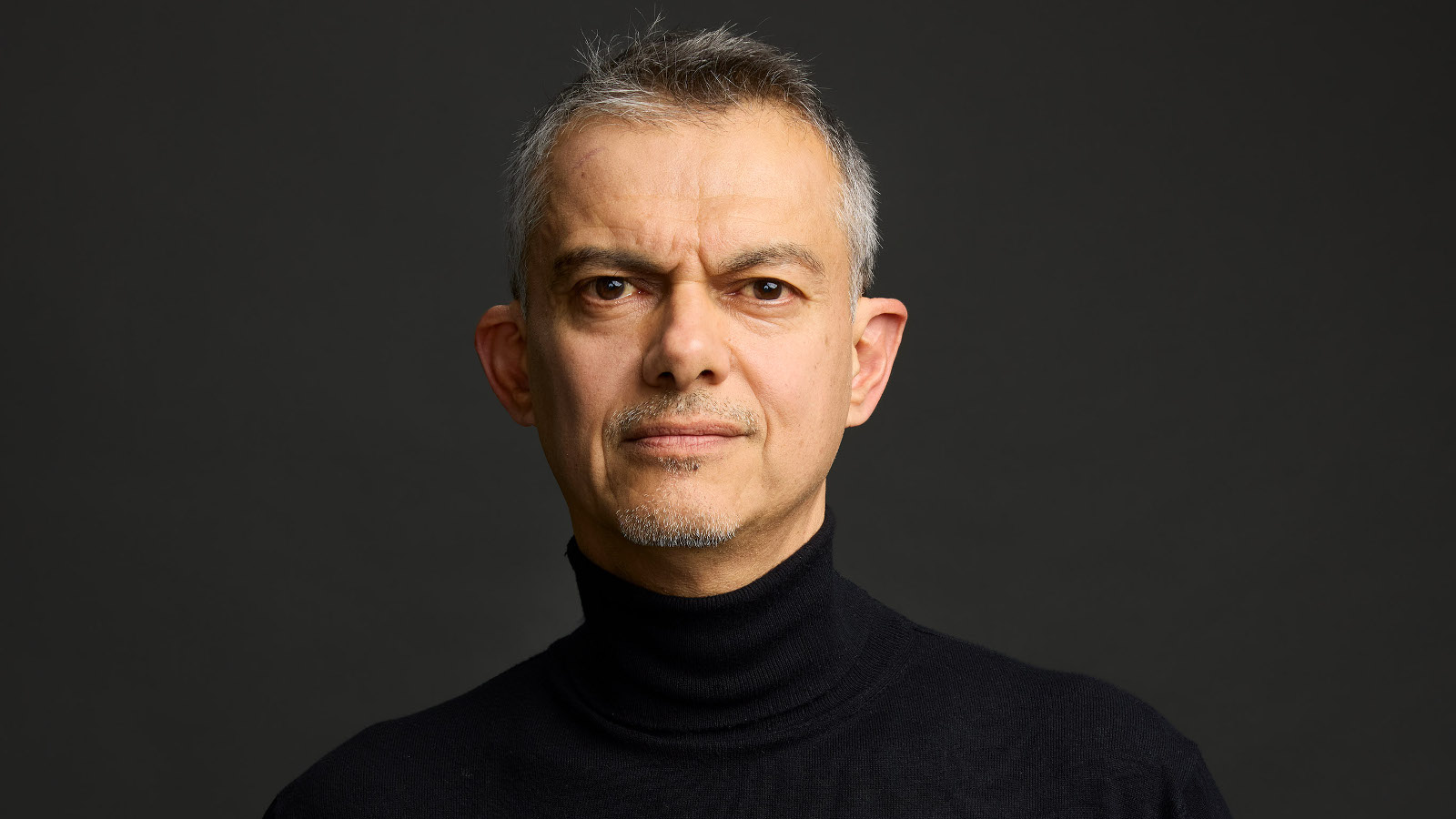 Kuvassa on Javier Torres puolivartalokuvassa ja hänellä on musta paita päällään.  Tausta on tumma.
