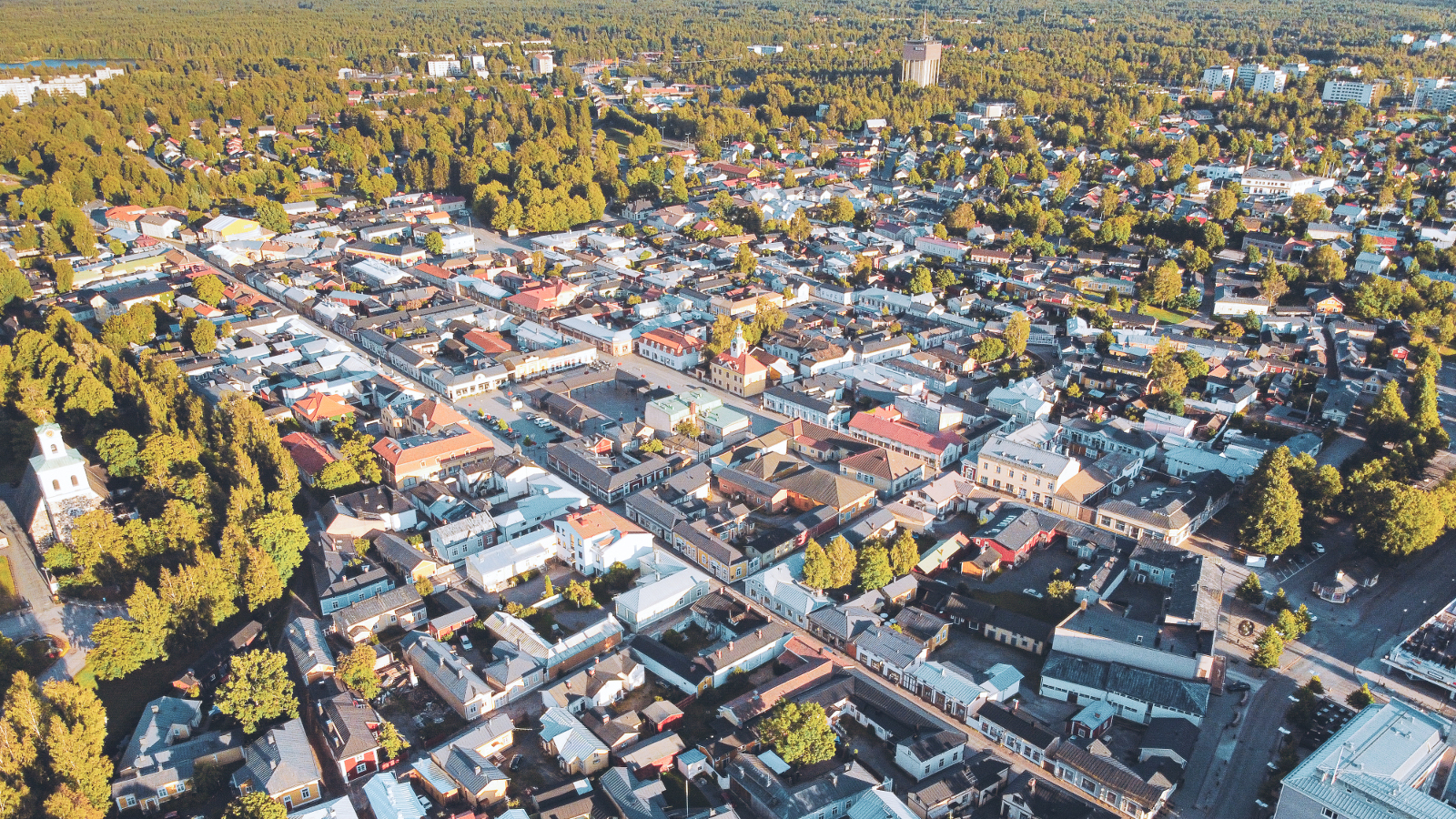 Kuvassa on Vanha Rauma kuvattuna ilmasta. Kuvassa näkyy taloja ja niiden välissä on vihreitä puita ja maisema näyttää ruutumaiselta. Kuva on kesältä.