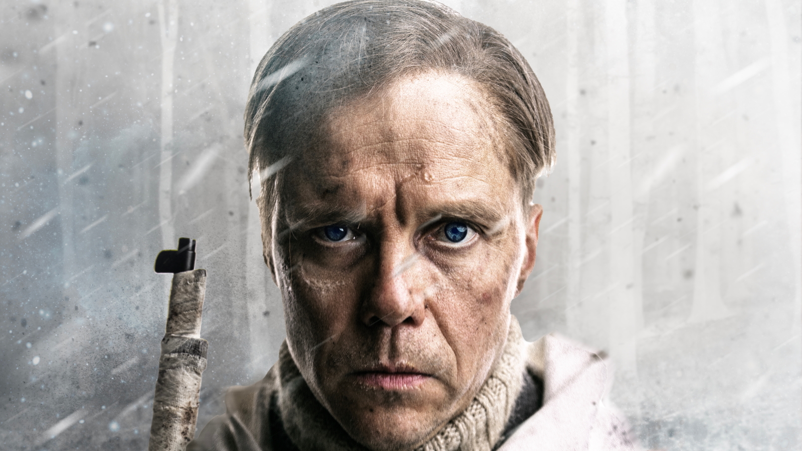 Kuvassa on Jarkko Lahti kasvokuvassa lyhyissä hiuksissa vakavailmeisenä. Kiväärin piippu näkyy vasemman olkapään yläpuolella. Taustalla on harmaata ja vinosti sataa lunta.