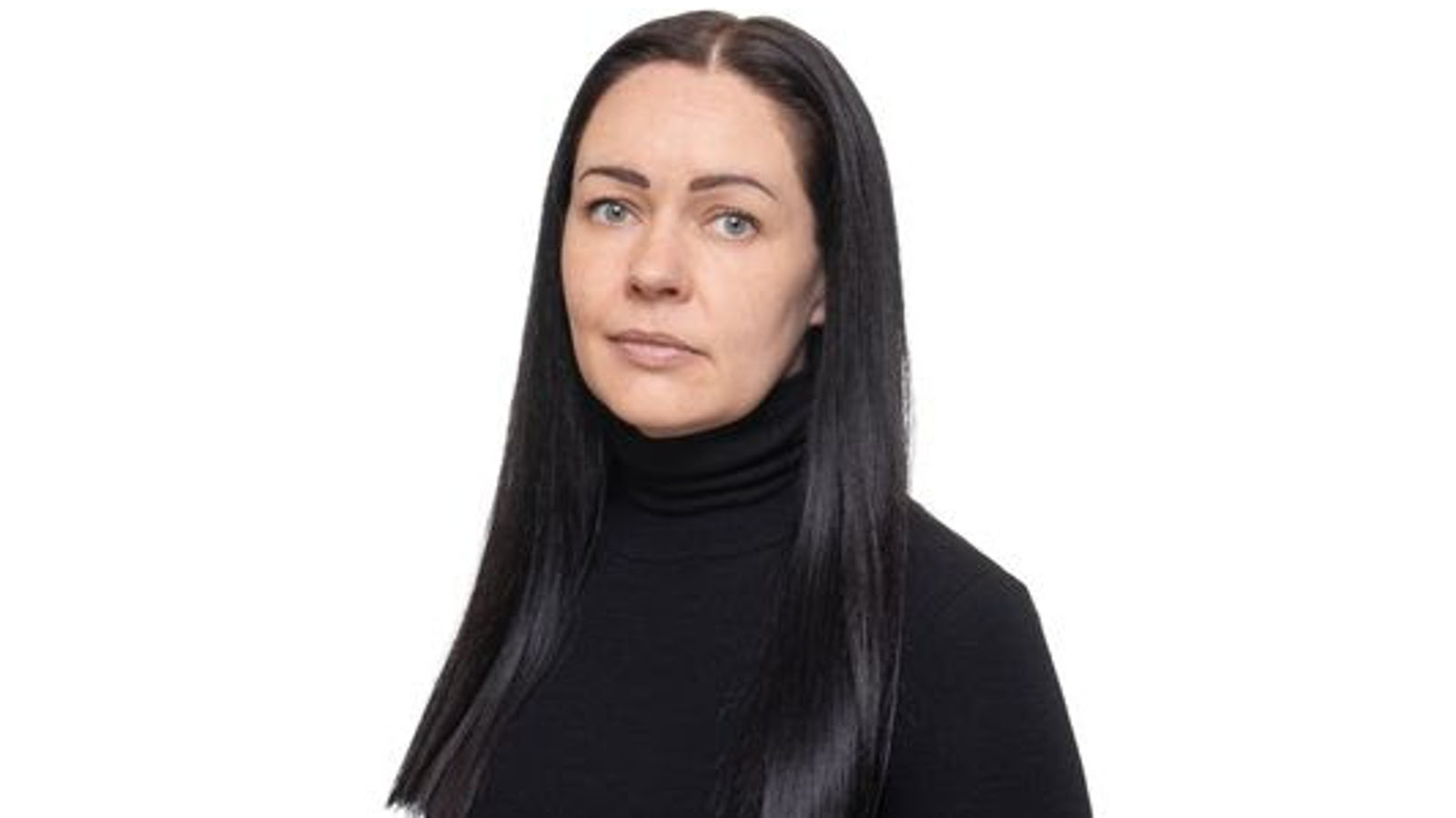 Kuvassa on Anna Pakarinen, jolla on ruskeat pitkät hiukset ja hänellä on musta pusero päällään. Tausta on valkoinen.