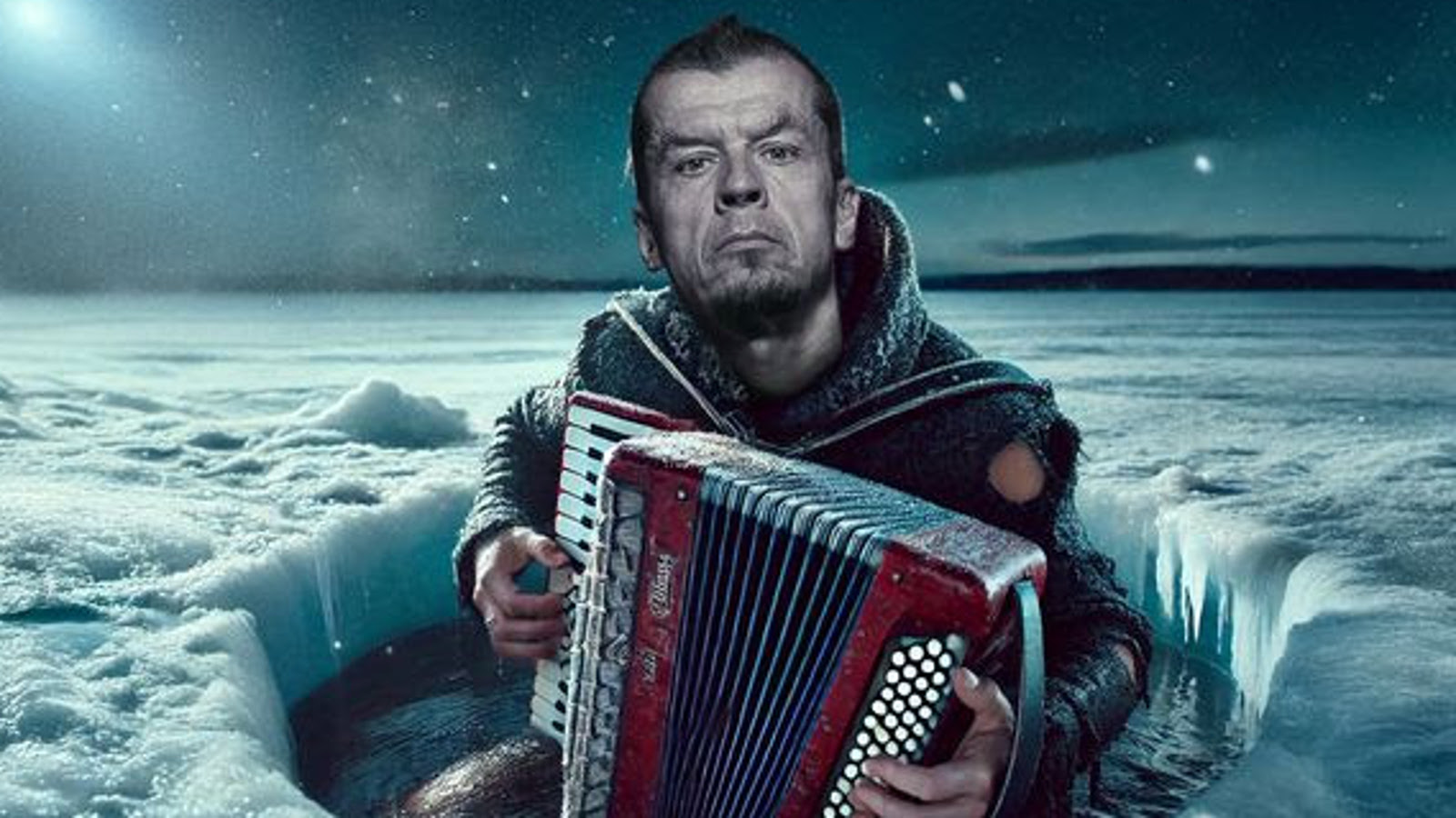 Kuvassa on lumisen järven jäällä  olevassa avannossa istumassa ja soittamassa harmonikkaa Kimmo Pohjonen. HÄnellä on villainen nuttu päällään. Taustan taivas on tumma iltataivas. 