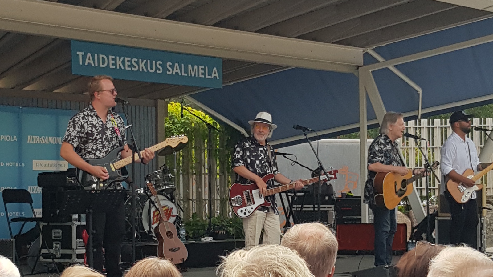 Kuvassa on Salmelan lavalla soittamassa kitaraa Tomi Juusela, hänestä oikealle Petteri Kokljuschkin kitarassa, Roni Kamras akustisessa kitarassa ja Lauri Holopainen kitarassa. Taustalla näkyy ylhäällä Taidekeskus Salmela -kyltti. 
