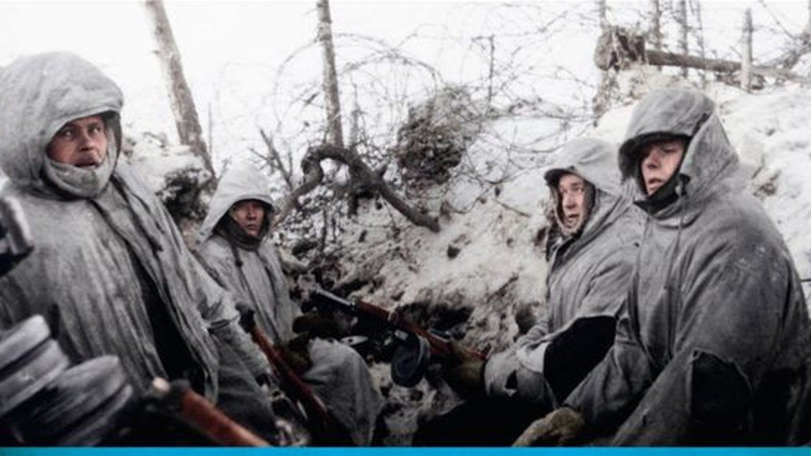 Kuvassa on sotilaita harmaatuneissa lumipuvuissa huput päässään juoksuhaudan laidalla harmaantuneessa lumessa takanaan piikkilankoja. Kuva on osa kirjankannesta.