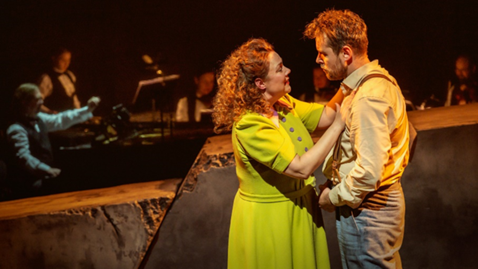 Kuvassa ovat etualalla seisomassa vasemmalla vaalean vihreässä mekossa Pihla Penttinen, joka pitää käsiään Waltteri Torikan rinnalla. Hänellä on vaalean ruskea pusero ja harmaat housut. Taustalla on himmeästi orkesteri tummalla taustalla.