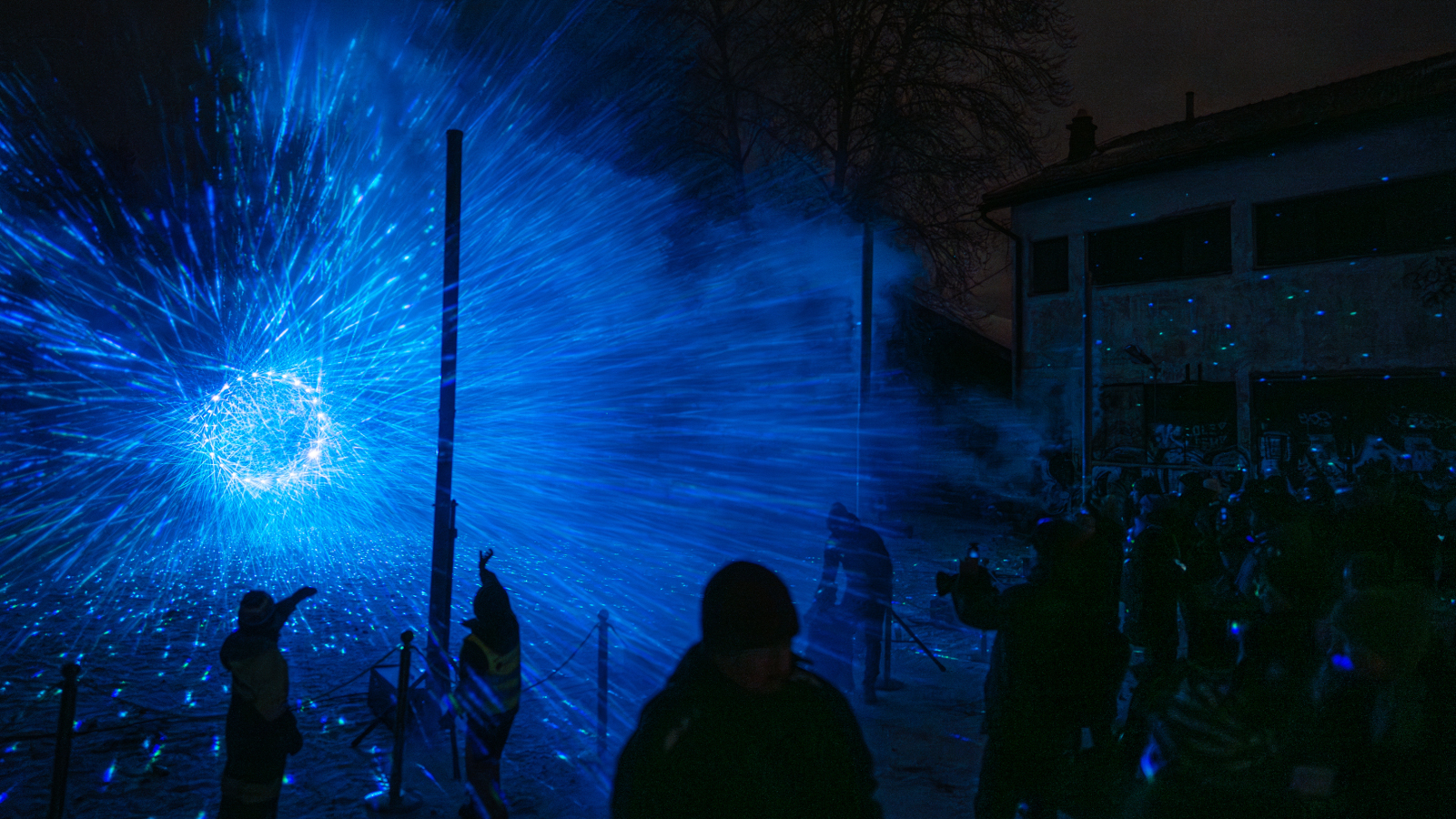 Kuvassa on tumma yökuva ja siinä näkyy kuu sekä sinistä valoa. 