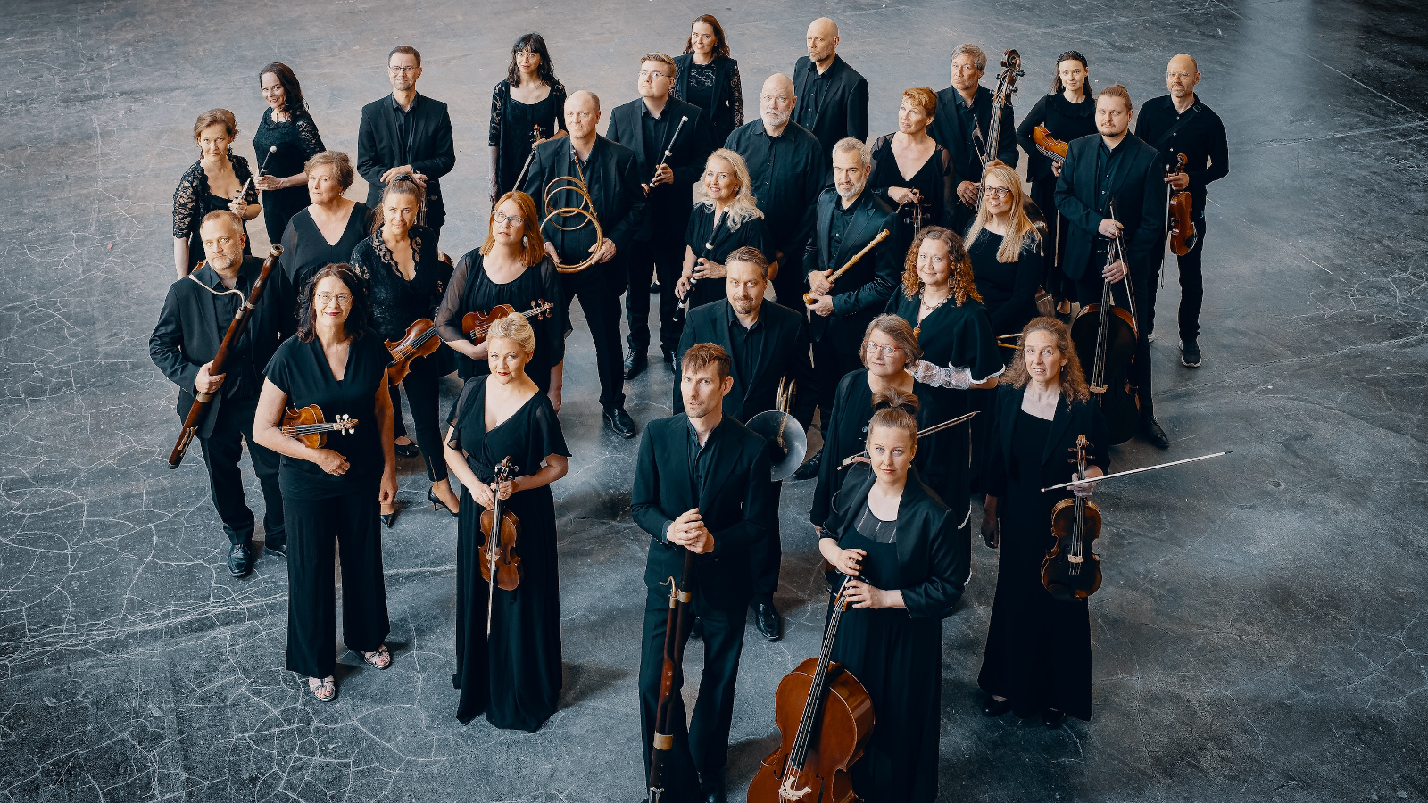 Kuvassa ovat Fibon soittajat mustissa puvuissa soittimineen kuvattuna yläviistosta.