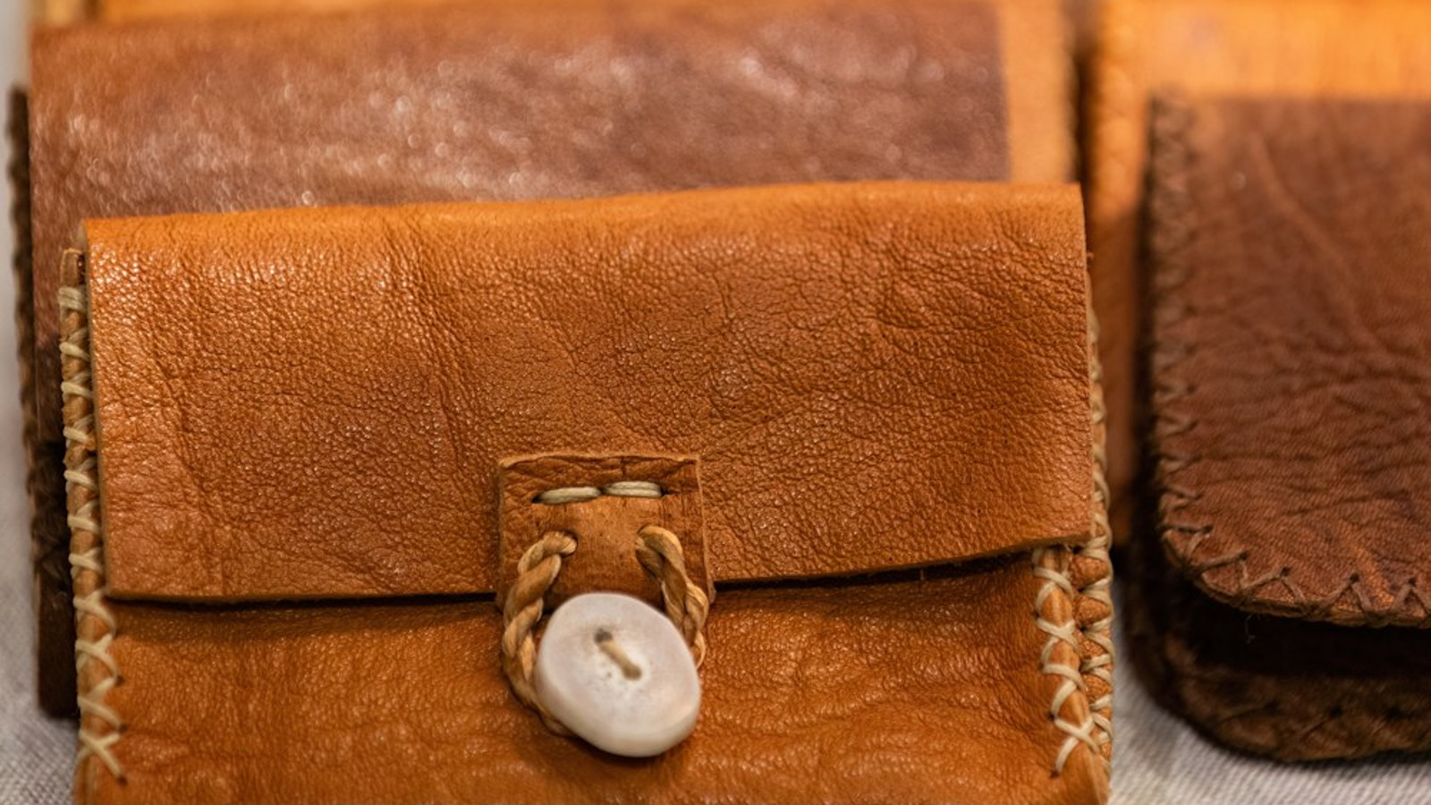 Kuvassa on rivissä keskiruskeita kukkaroita. 